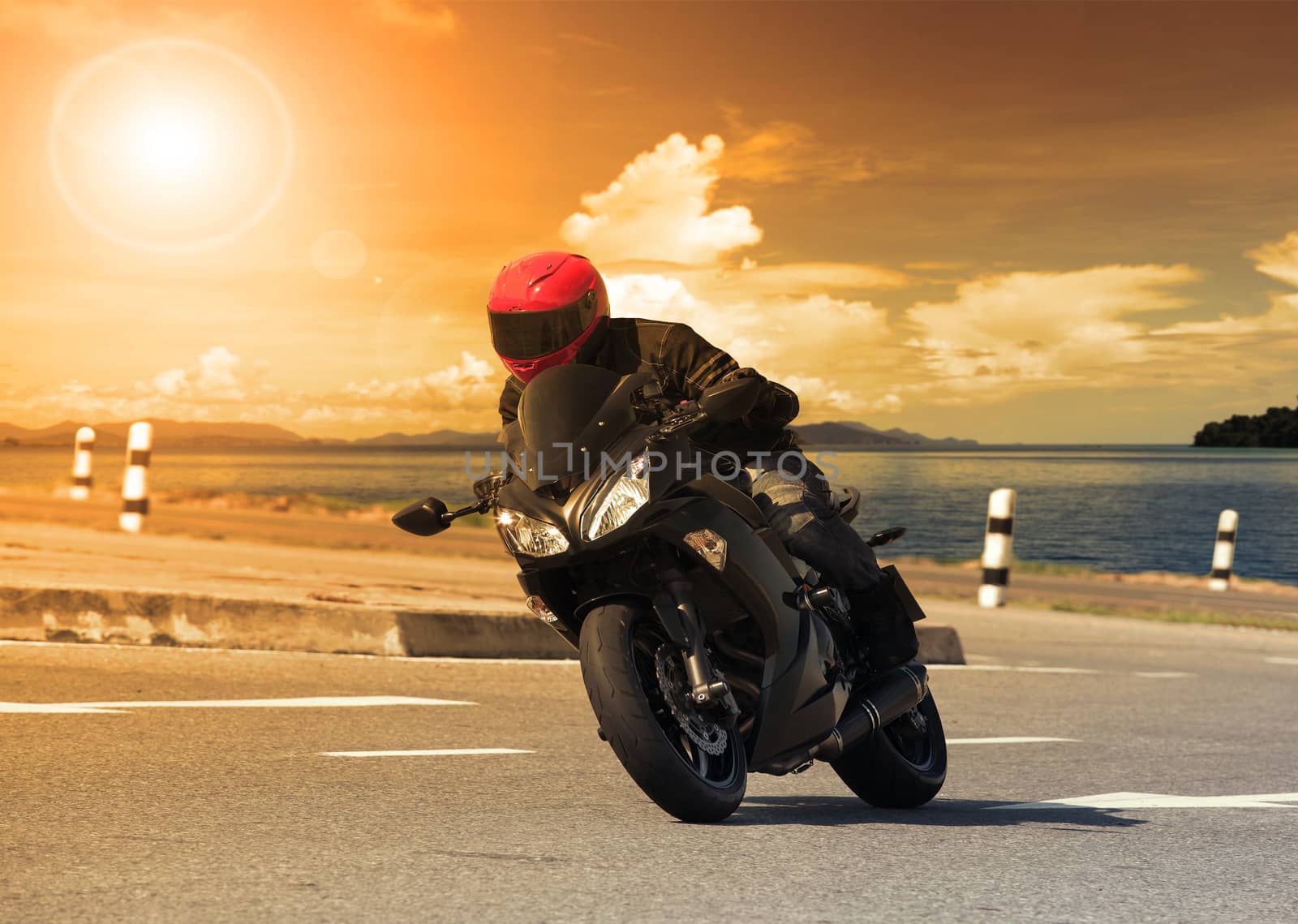 young man riding big bike motorcycle against sharp curve of asphalt high ways road with rural lake scene use for male adventure activities and motor sport hobby on holiday vacation