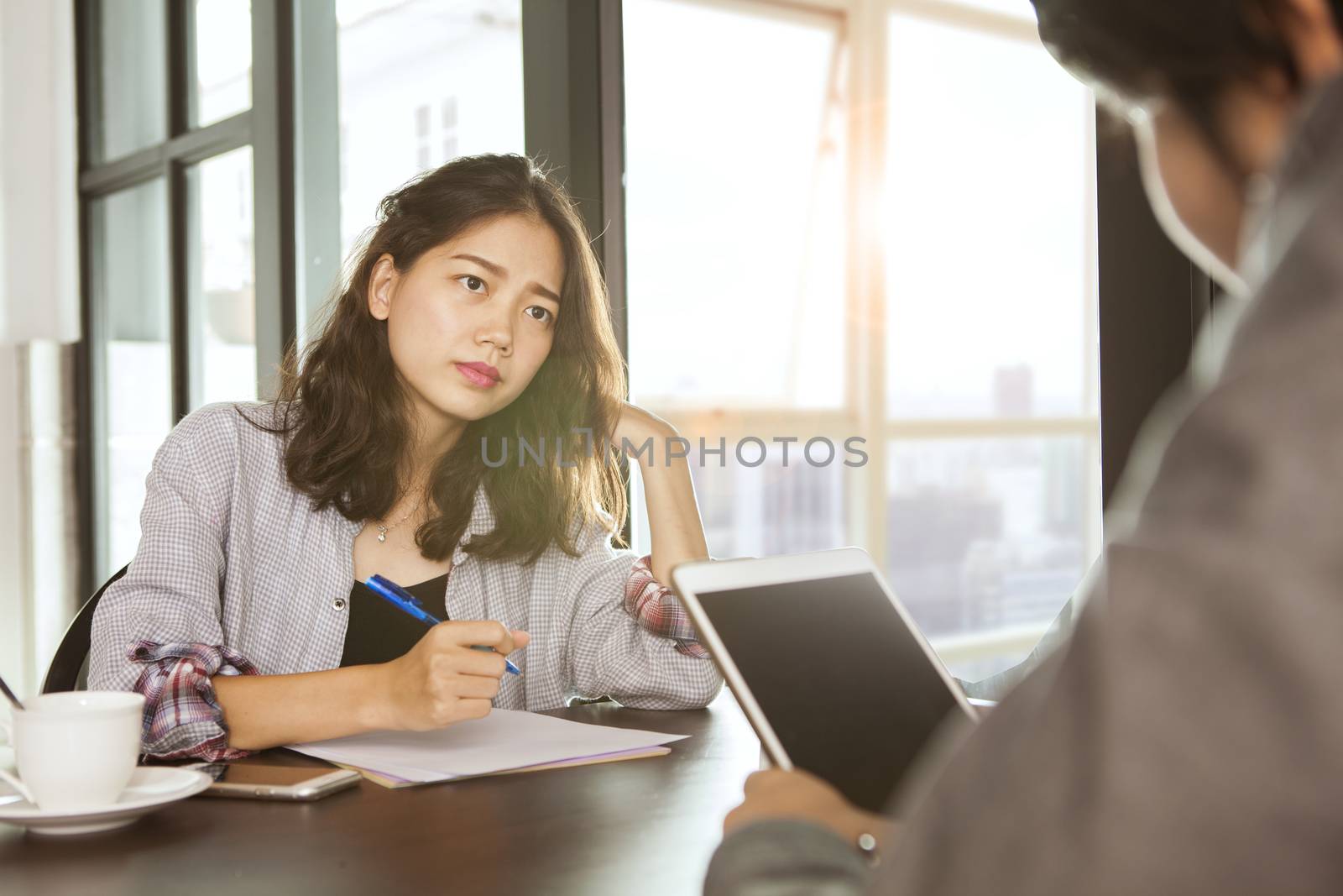 working asian woman team meeting with serious problem on office working table