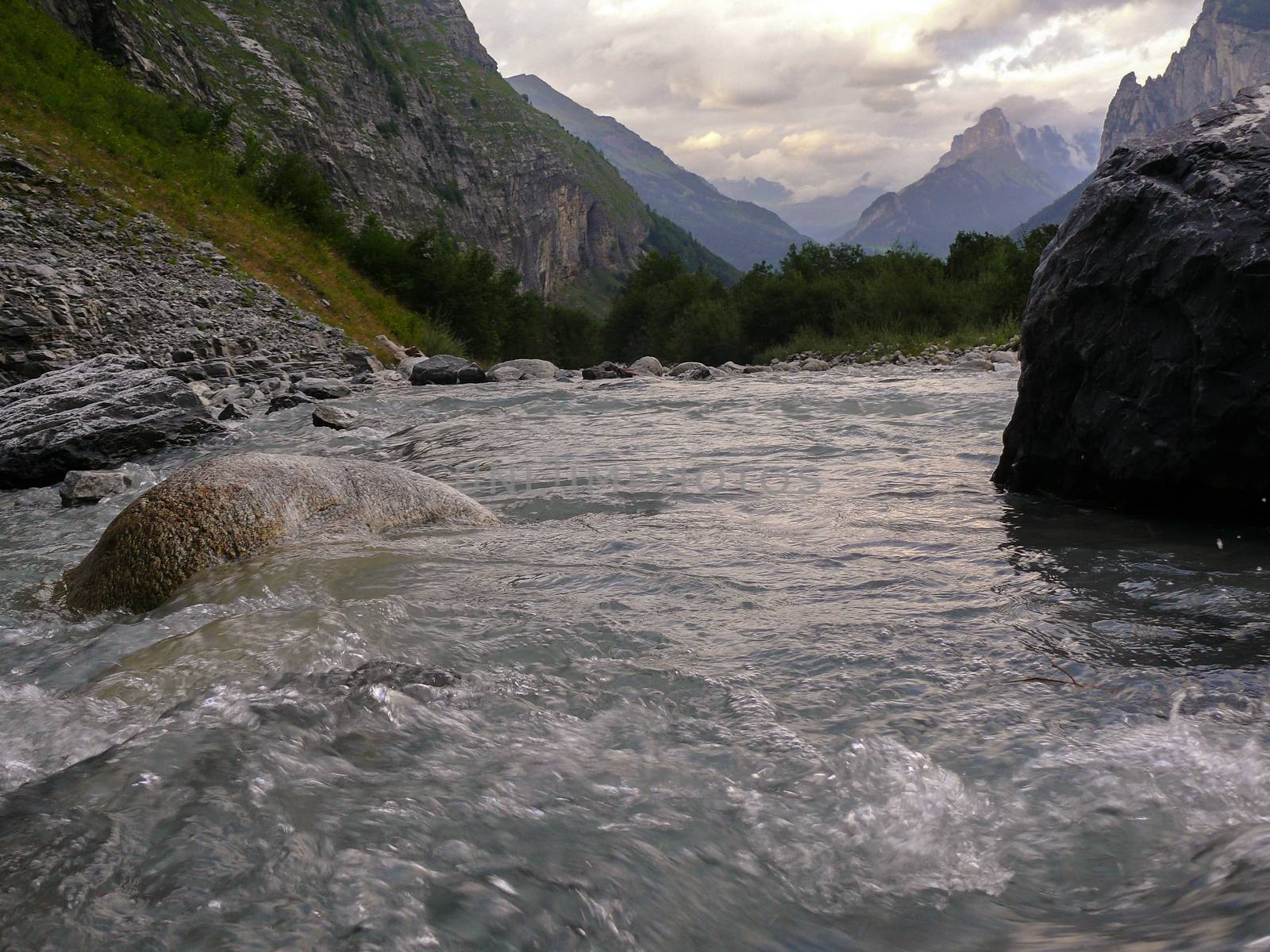 alpine mountain water stream on sunset in Switzerland by evolutionnow