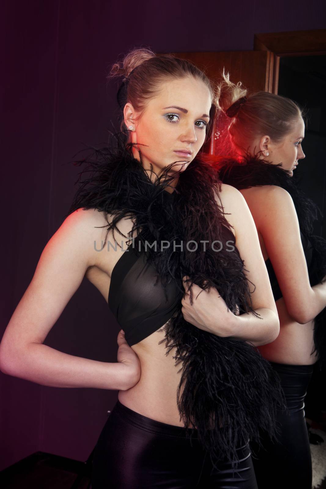 extravagant dancer near a mirror in black scenic clothes