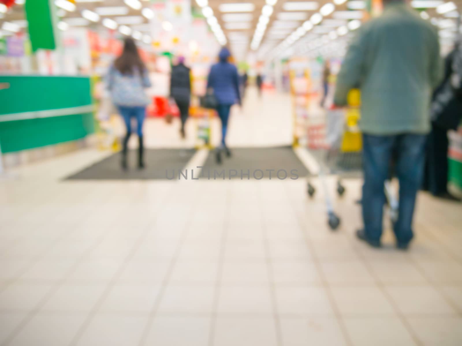 Abstract blurred entrance area of supermarket with unrecognizable customers as background
