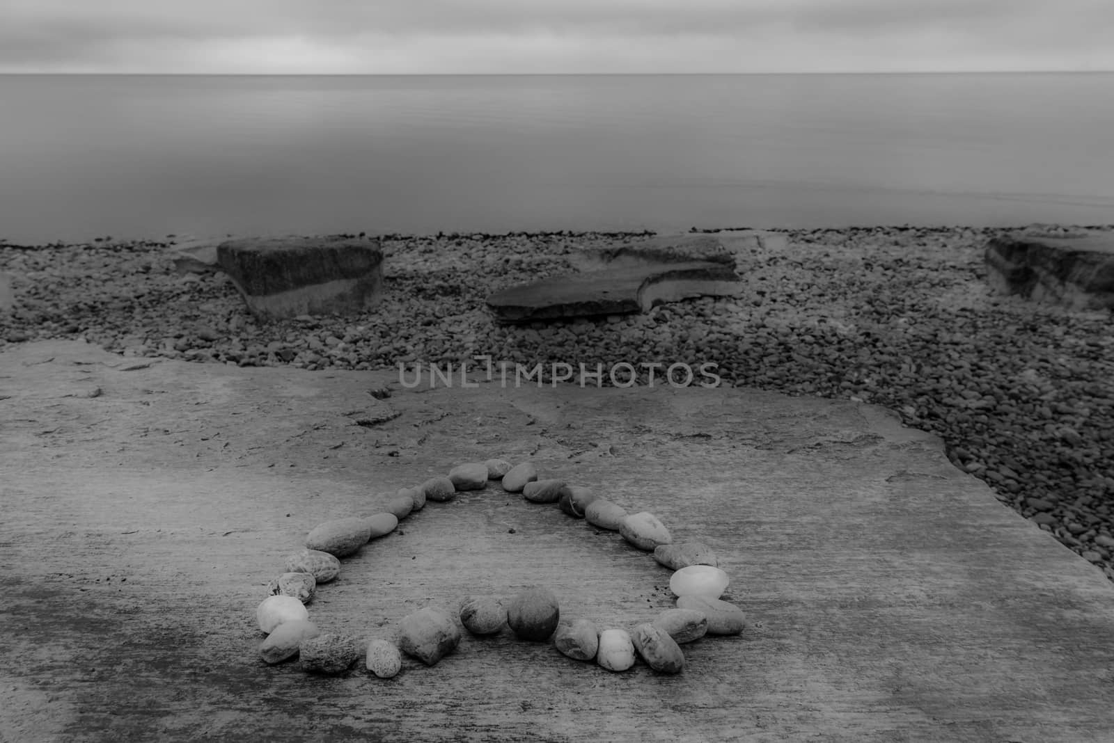 Dreamy image in monochrome settings with a heart shape made from stones, on the shore of the lake Bodensee, city FriedrichsHafen, Germany