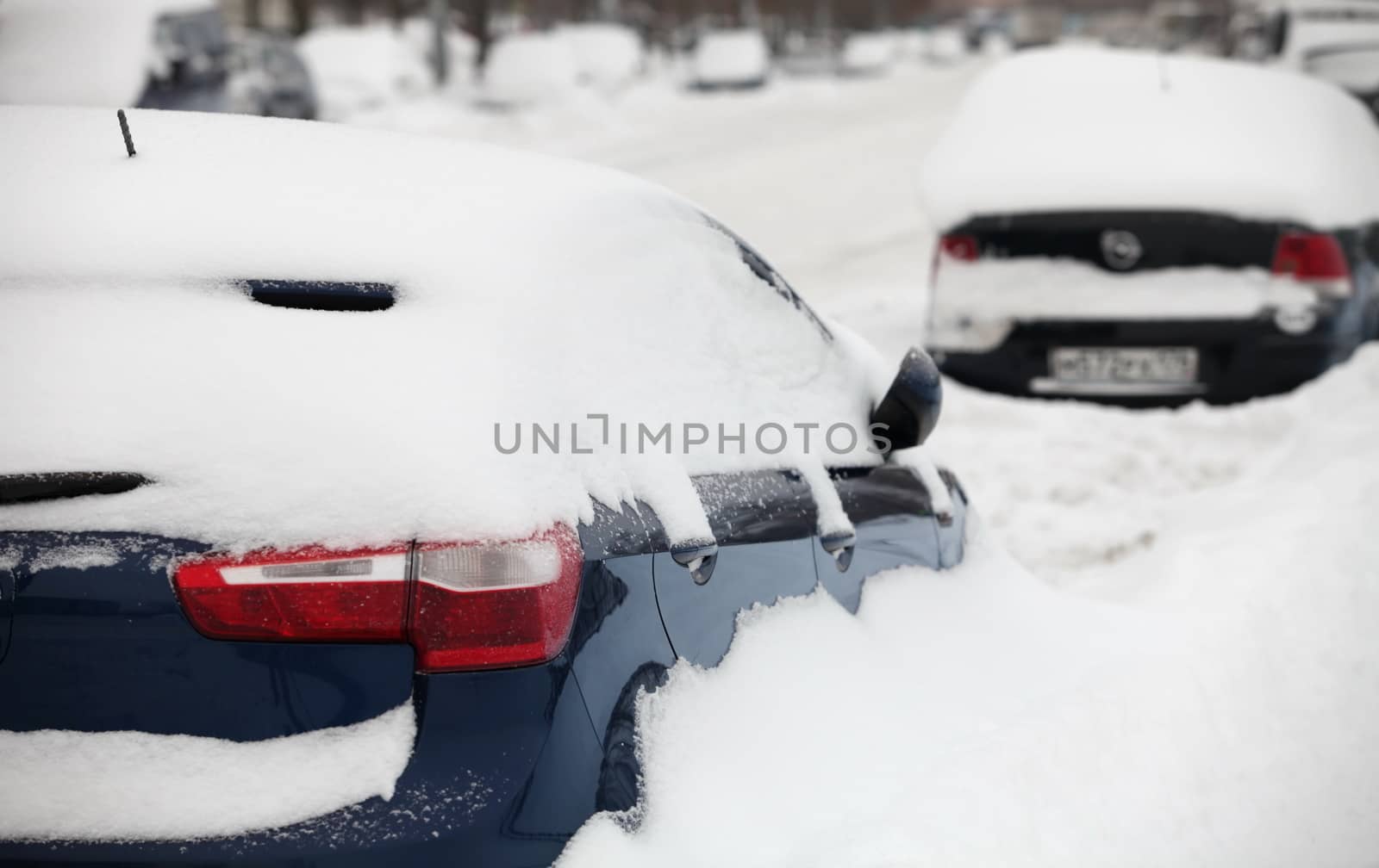 cars covered with snow in the parking