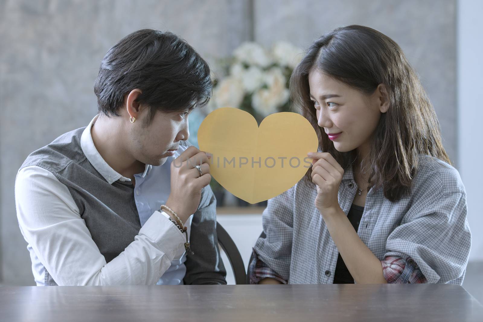 couples of asian man and woman holding heart shape paper cut with happiness emotion ,peple love conceptual