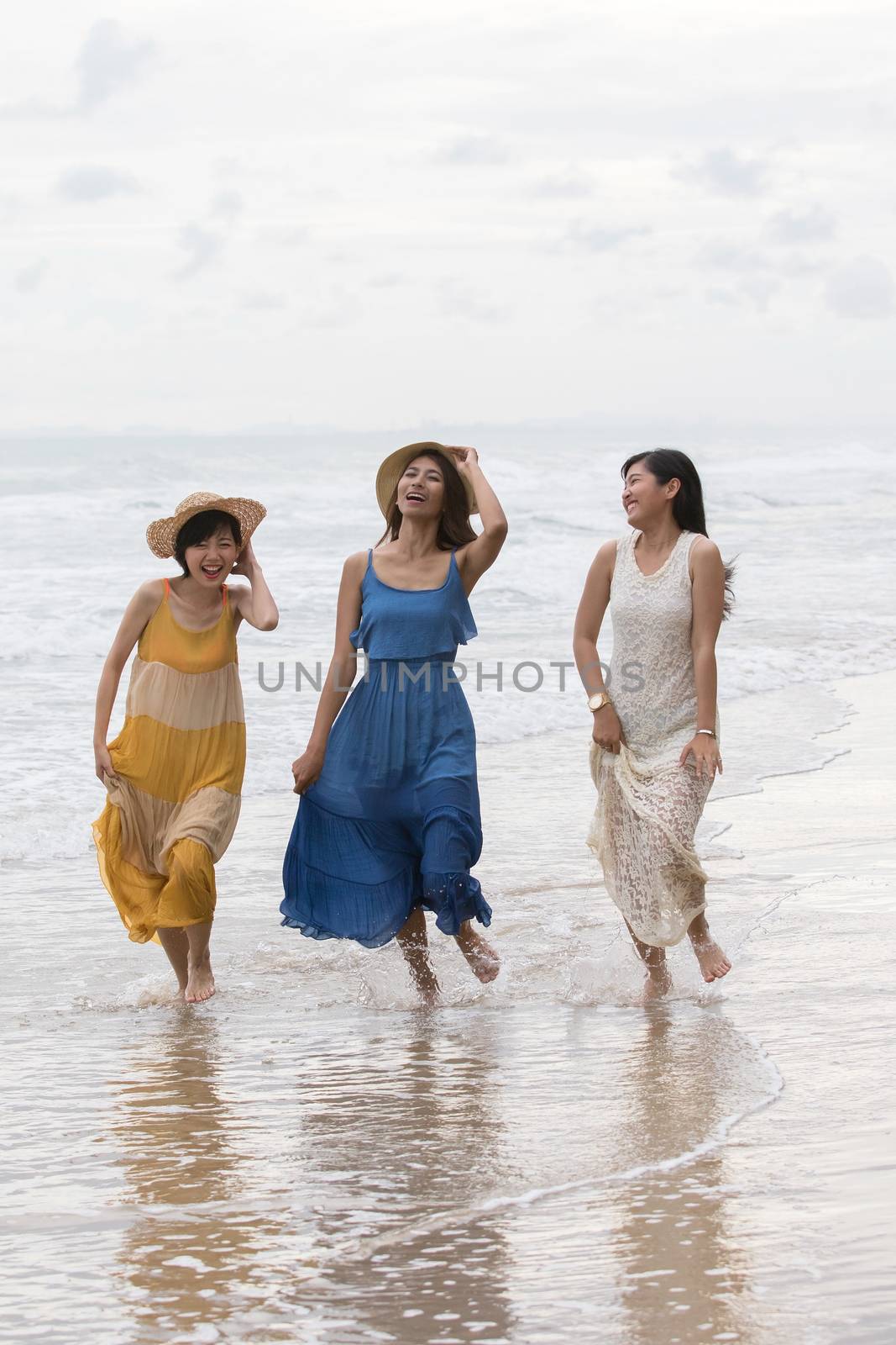 portrait of young asian woman with happiness emotion wearing beautiful dress walking on sea beach and laughing joyful use for people relaxing vacation on destination