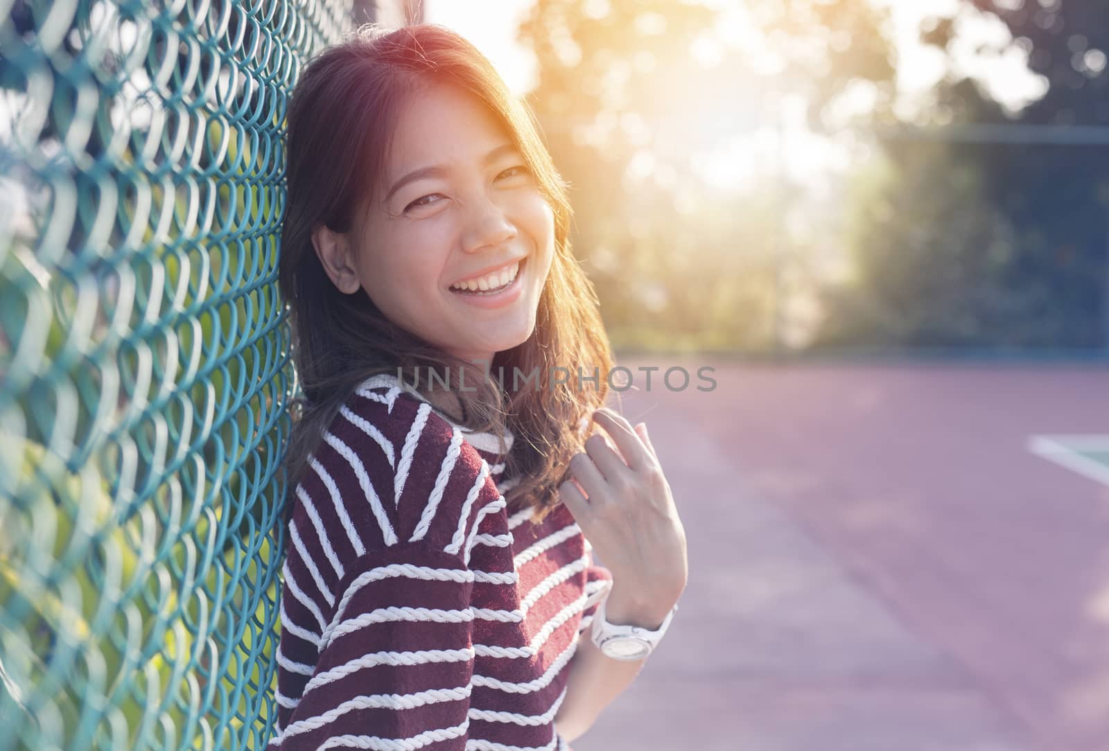 beautiful asian younger woman laughing with happiness emotion and sun light behind