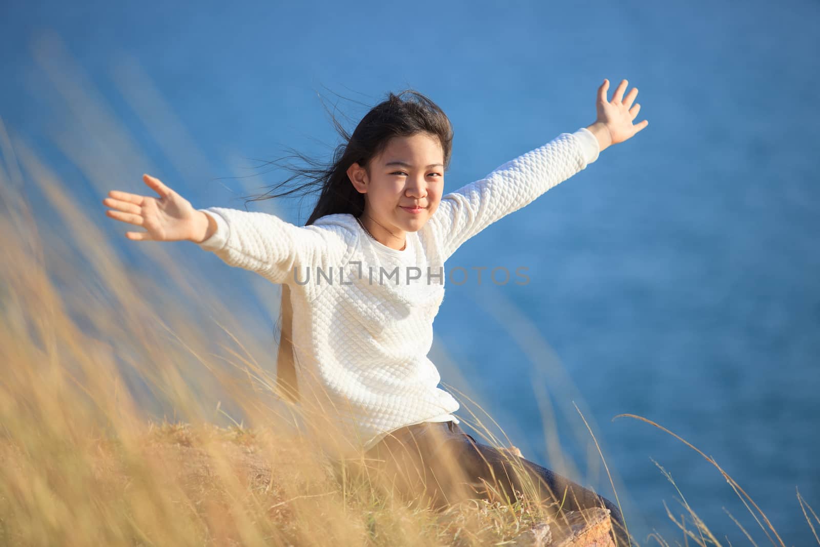 portrait of asian girl relaxing emotion sitting in grass field a by khunaspix