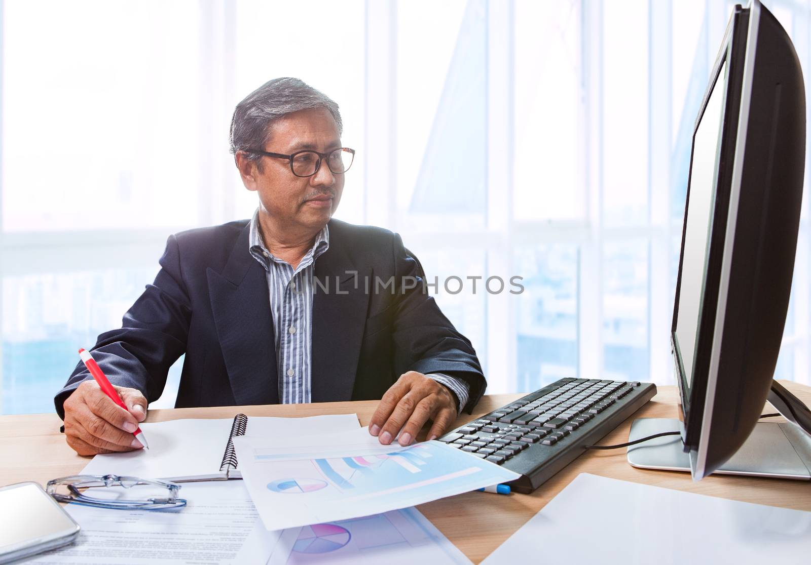 senior business man working on office tabel with computer and bu by khunaspix