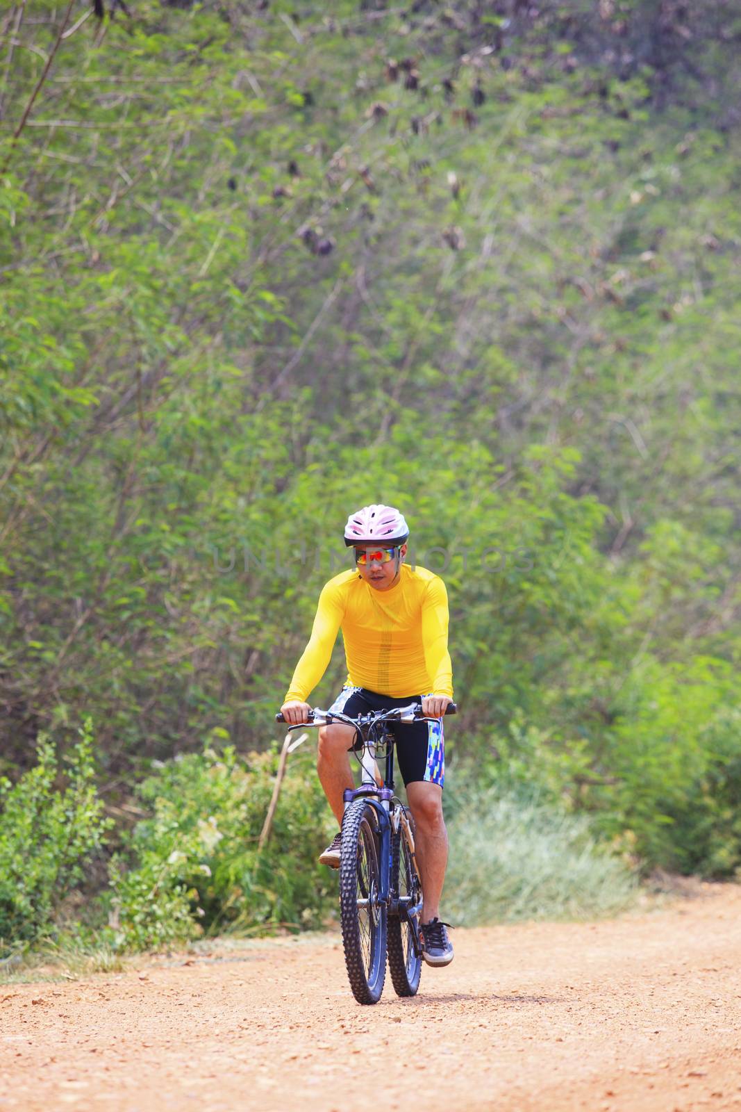 young man riding mountain bike in dusty road use for sport leisure and healthy activities