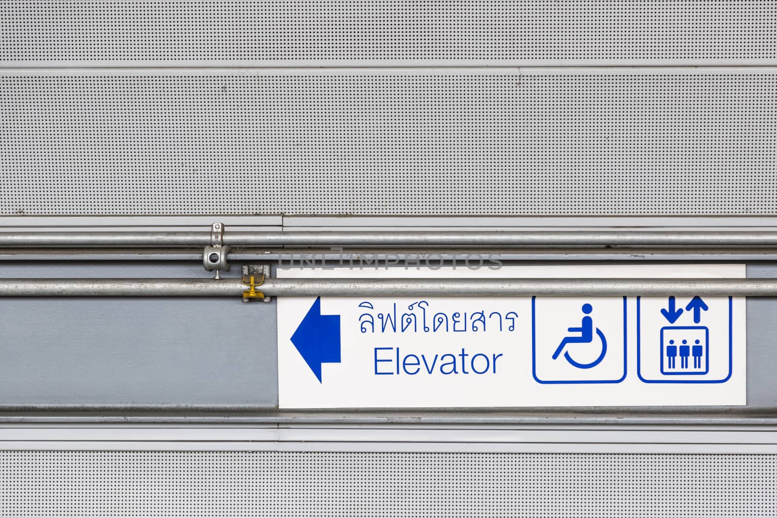 blue sign with human symbo and man on the wheel cahir symbo telling the elevator at the left on the wall at train station in Bangkok, Thailand, 2016 