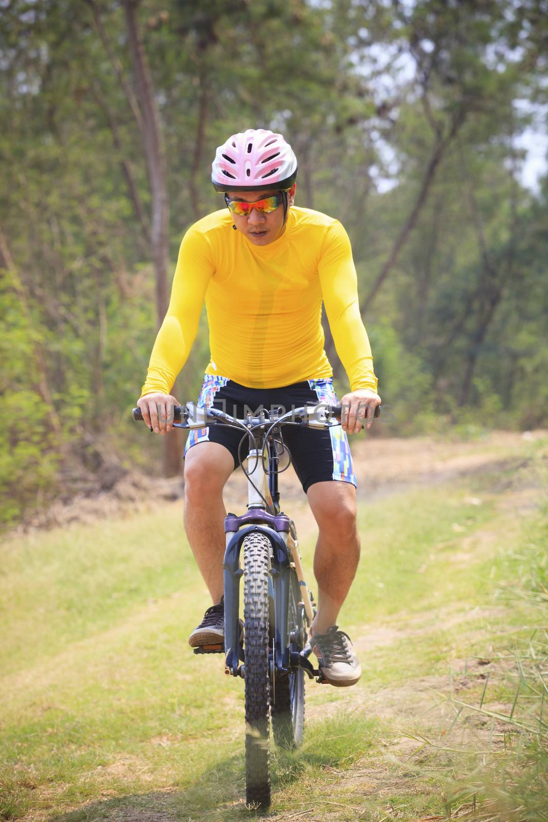 man and mountain bike riding in jungle track use for bicycle spo by khunaspix