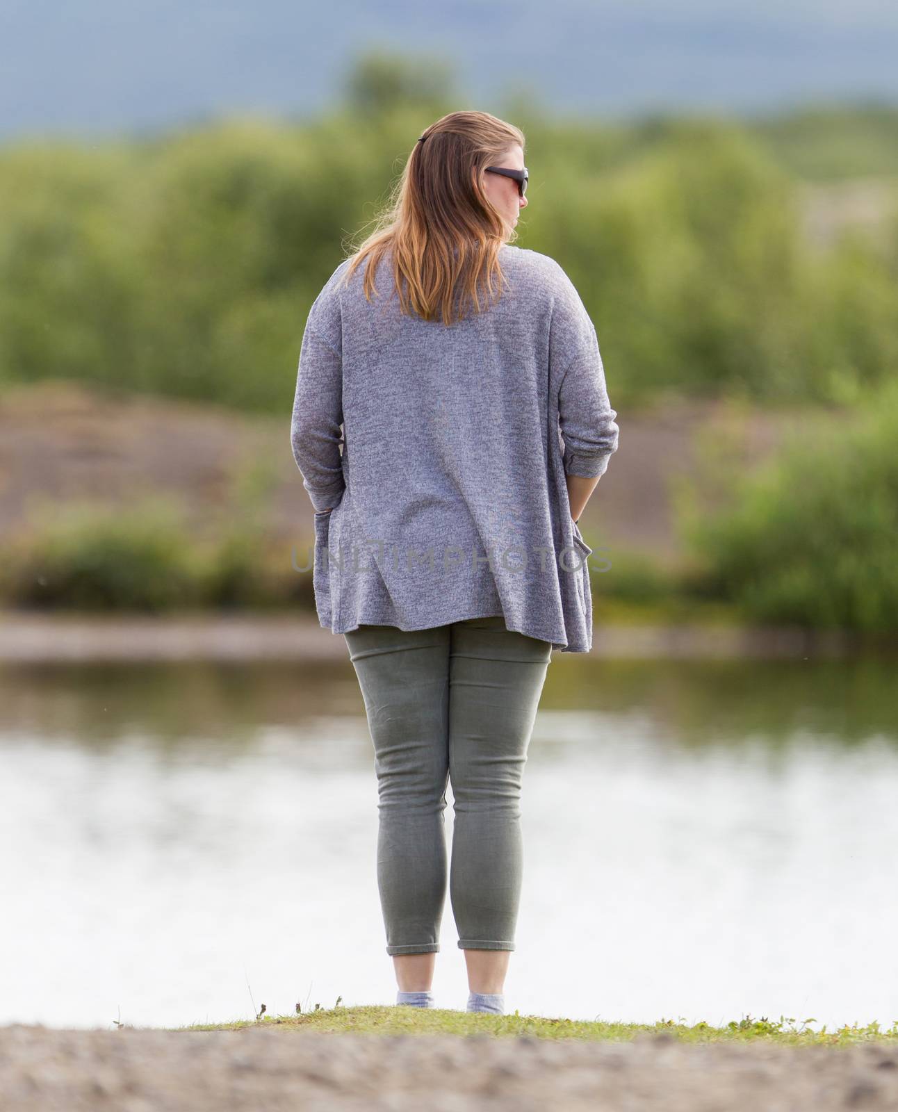 Woman standing at the riverside by michaklootwijk