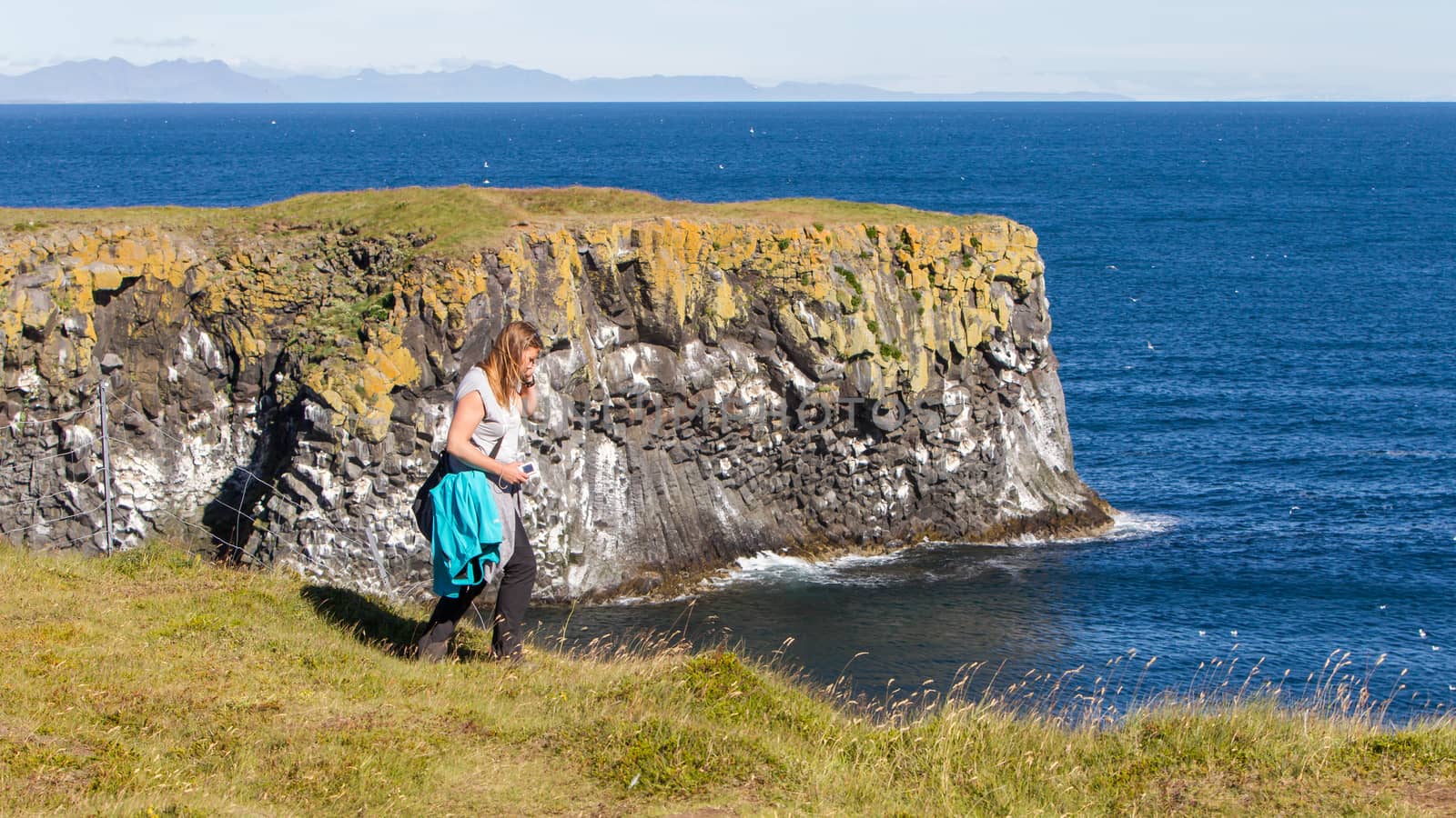 Woman on the edge of the cliff - Iceland by michaklootwijk