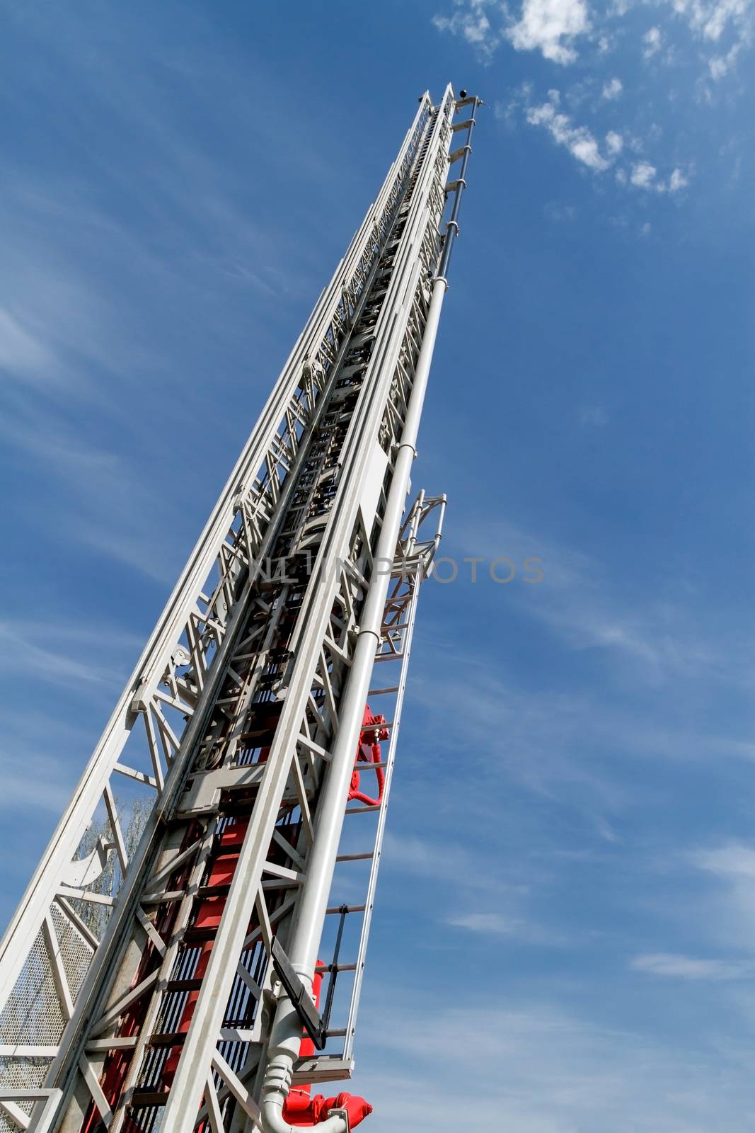 Sliding fire ladder against cloudy, blue sky