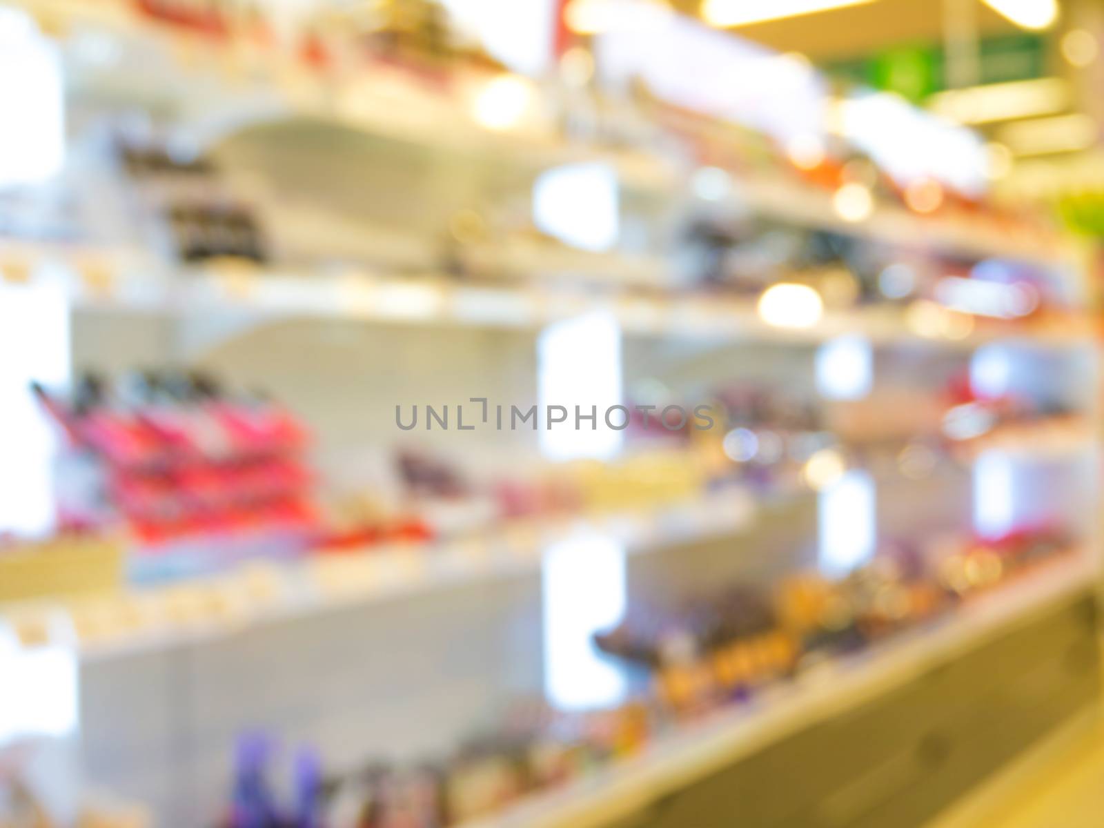 Abstract blurred supermarket aisle with colorful makeup cosmetic goods shelves as background