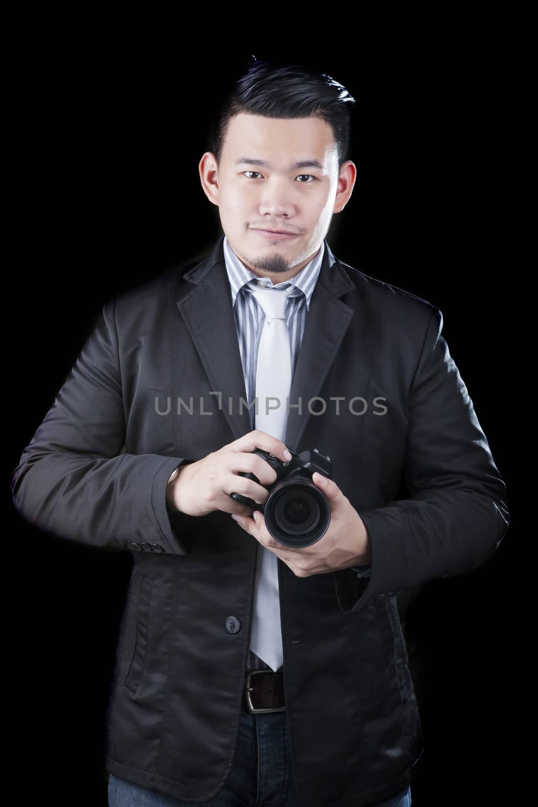 young asian man holding dslr camera take a photography by low key ,low light white dark background technical use for people activities and human occupation career