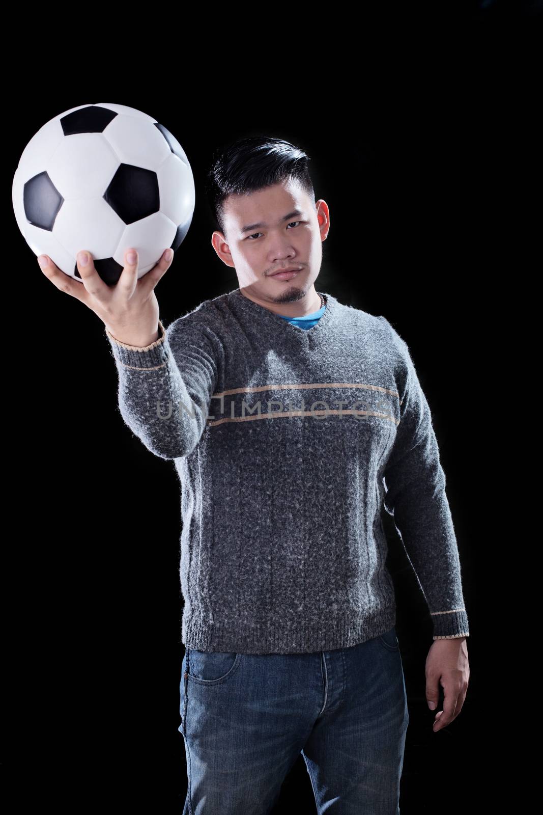 young asian man and soccer ball on dark background use for football mania