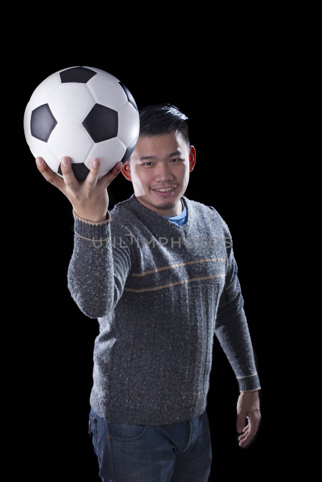 face of soccer lover holding football ball isolated black background use for sport and people activities theme 
