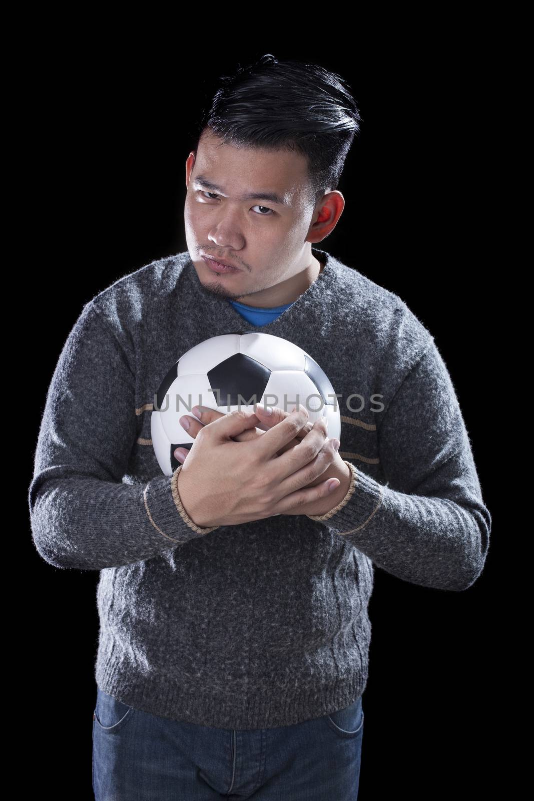 face of soccer lover holding football ball isolated black background use for sport and people activities theme