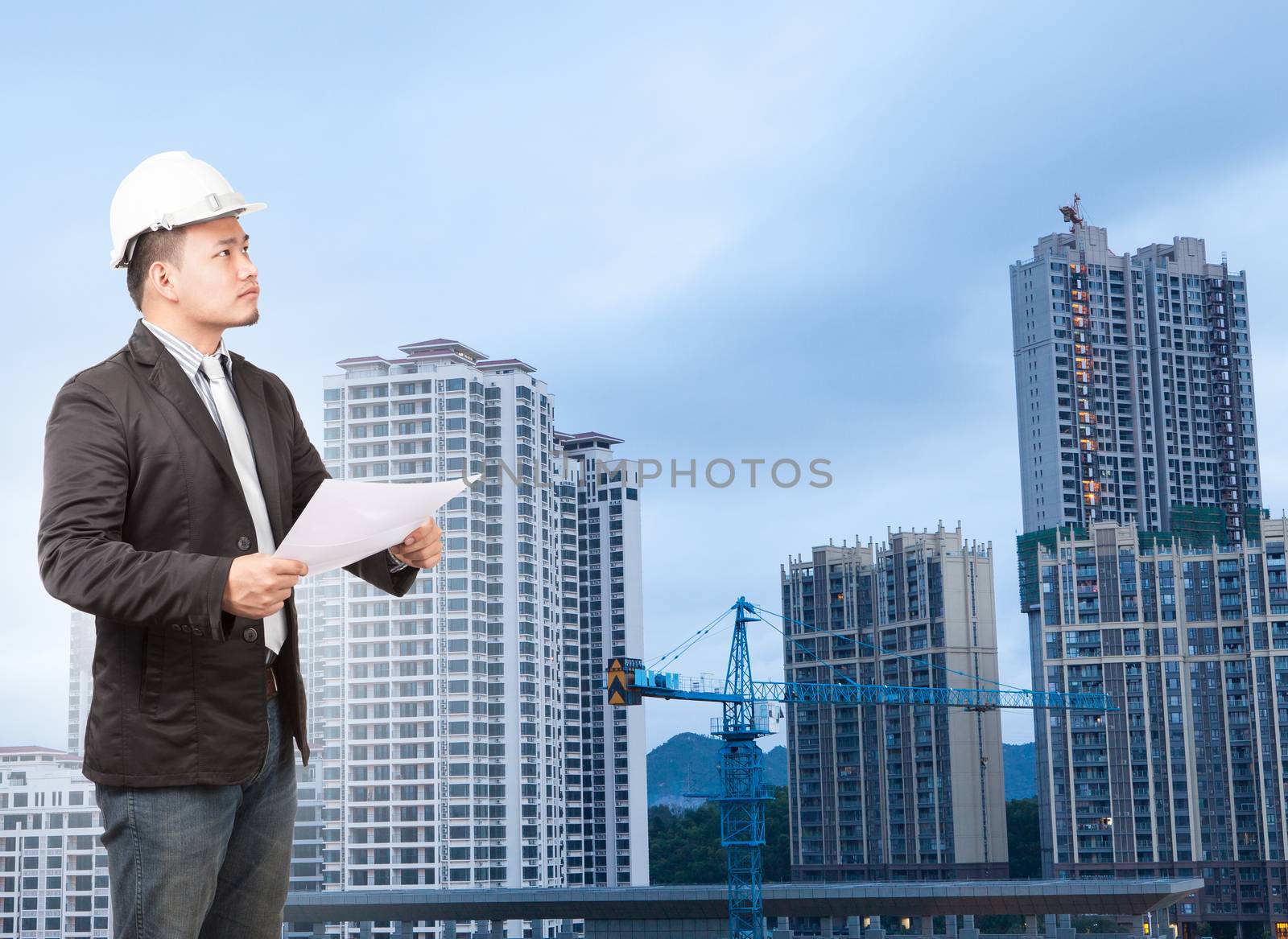 engineering man wearing western suit and safety helmet with buil by khunaspix