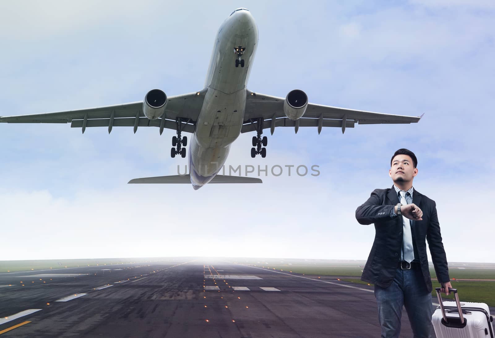young business man standing in airport runways with belonging lu by khunaspix