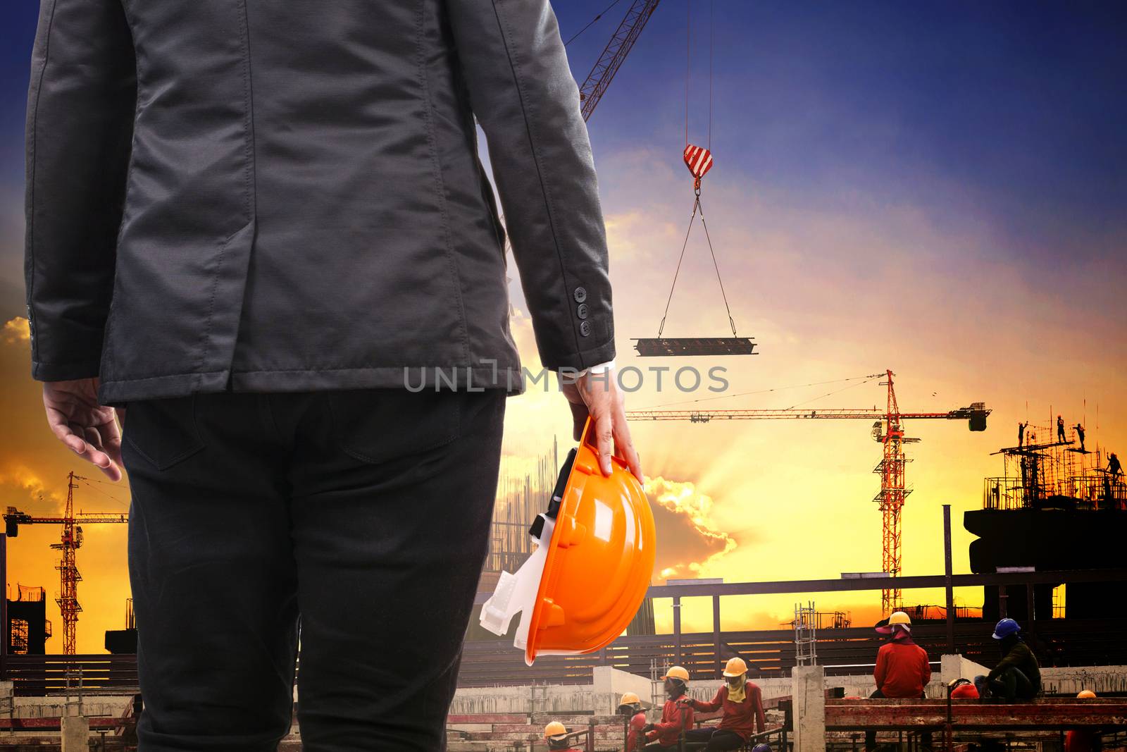 engineering man holding safety helmet and working in building construction site against builting structure project site 