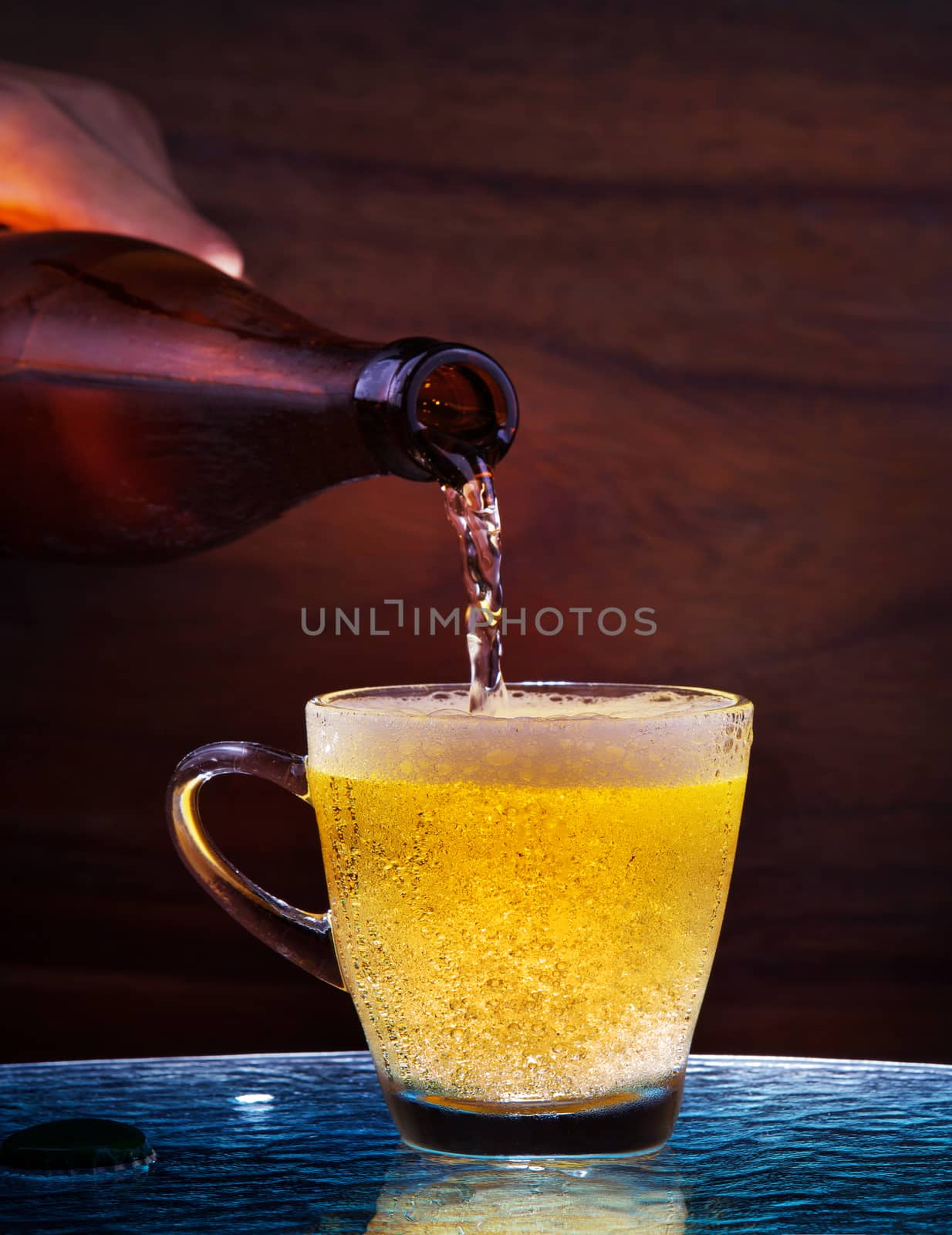 lager beer drain from bottle to glass on table with wood background use for alcohol drinking beverage  in adult pub ,bar and restaurant