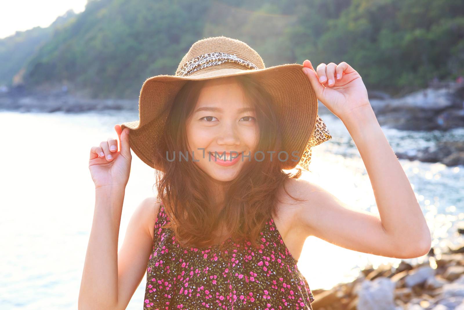 portrait face of beautiful woman wearing wide straw hat standing at sea side eyes looking to camera use for people on vacation and natural beauty of young and teen