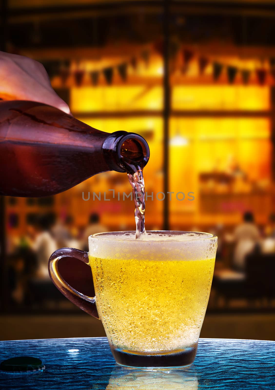 lager beer drain from bottle to glass on table with beautiful lighting of snack bar use for alcohol drinking beverage  in adult pub ,bar and restaurant