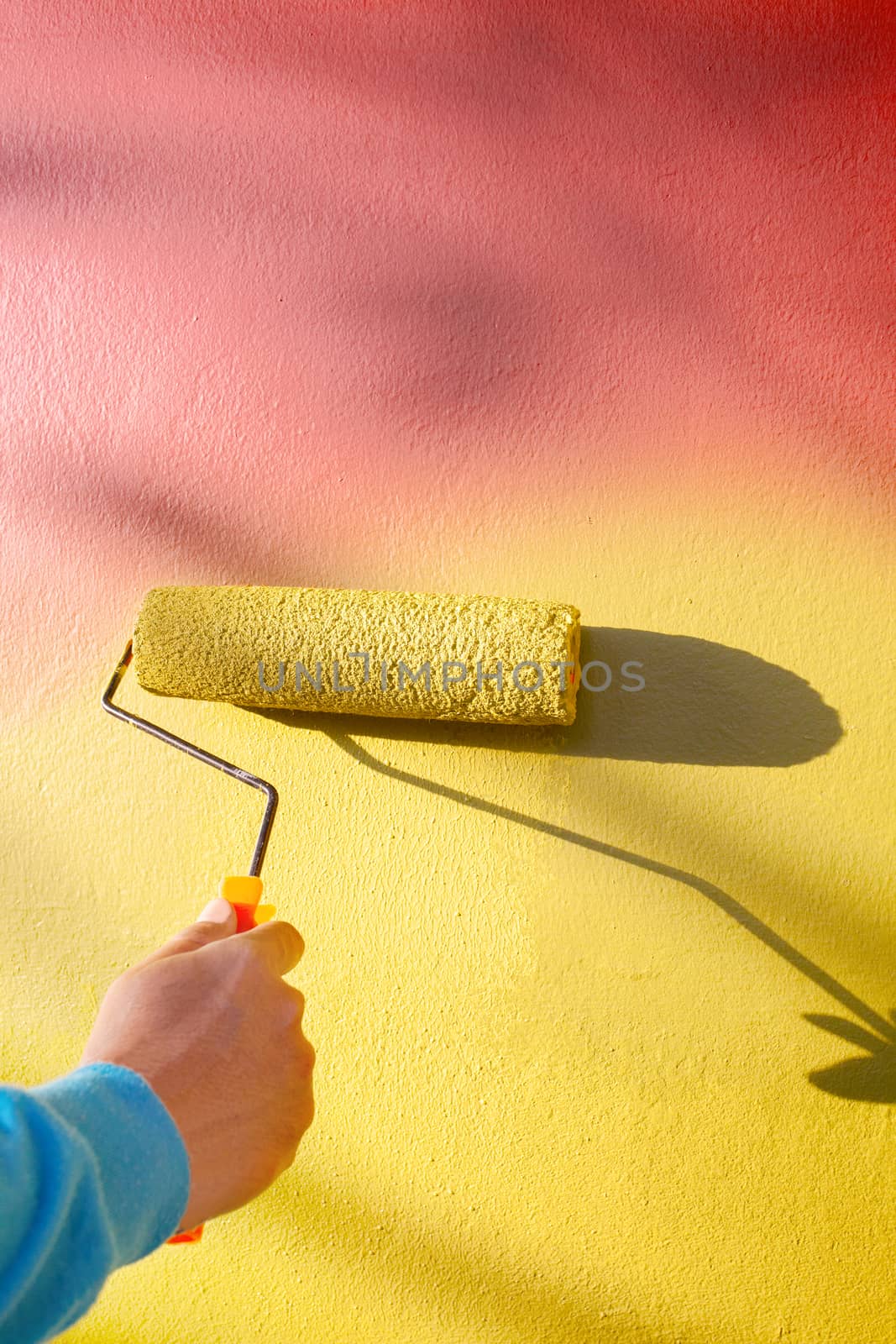 hand painting yellow wall by roller painter brush