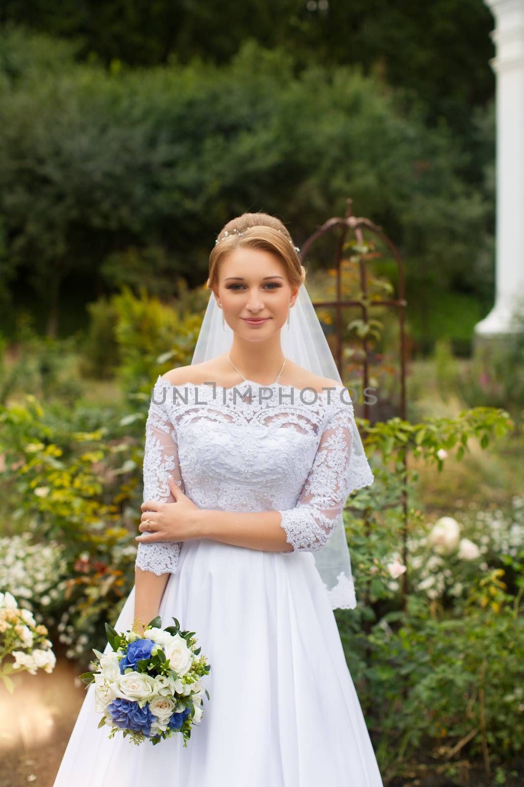 Portrait of a bride in a stylish white dress close-up outdoors