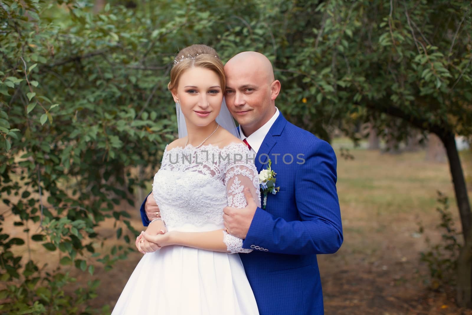 Bride gently pressed her to the groom on the background of nature