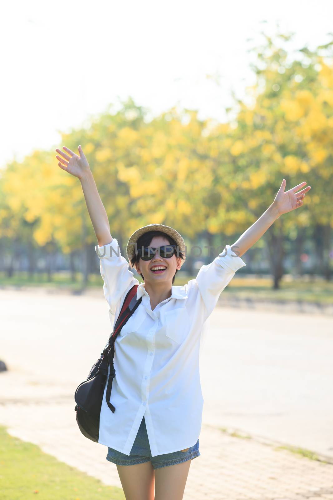 young beautiful woman wearing white shirts ,straw hat and sun glasses rising hand victory shape and toothy smiling use for modern and people lifestyle feeling free 