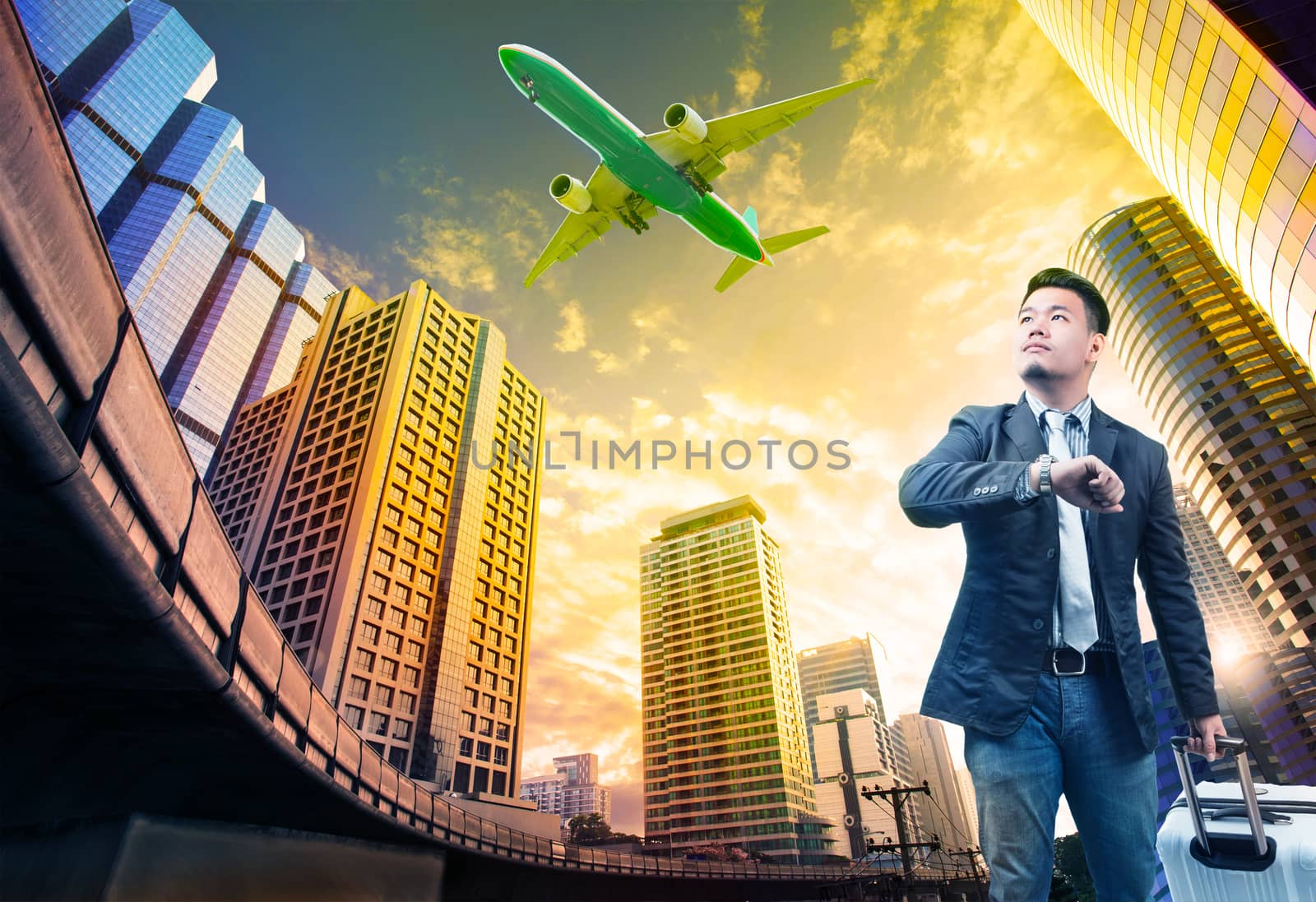 young business man and belonging luggage standing against building urban scene looking to sky with passenger jet plane flying above use for people in traveling theme
