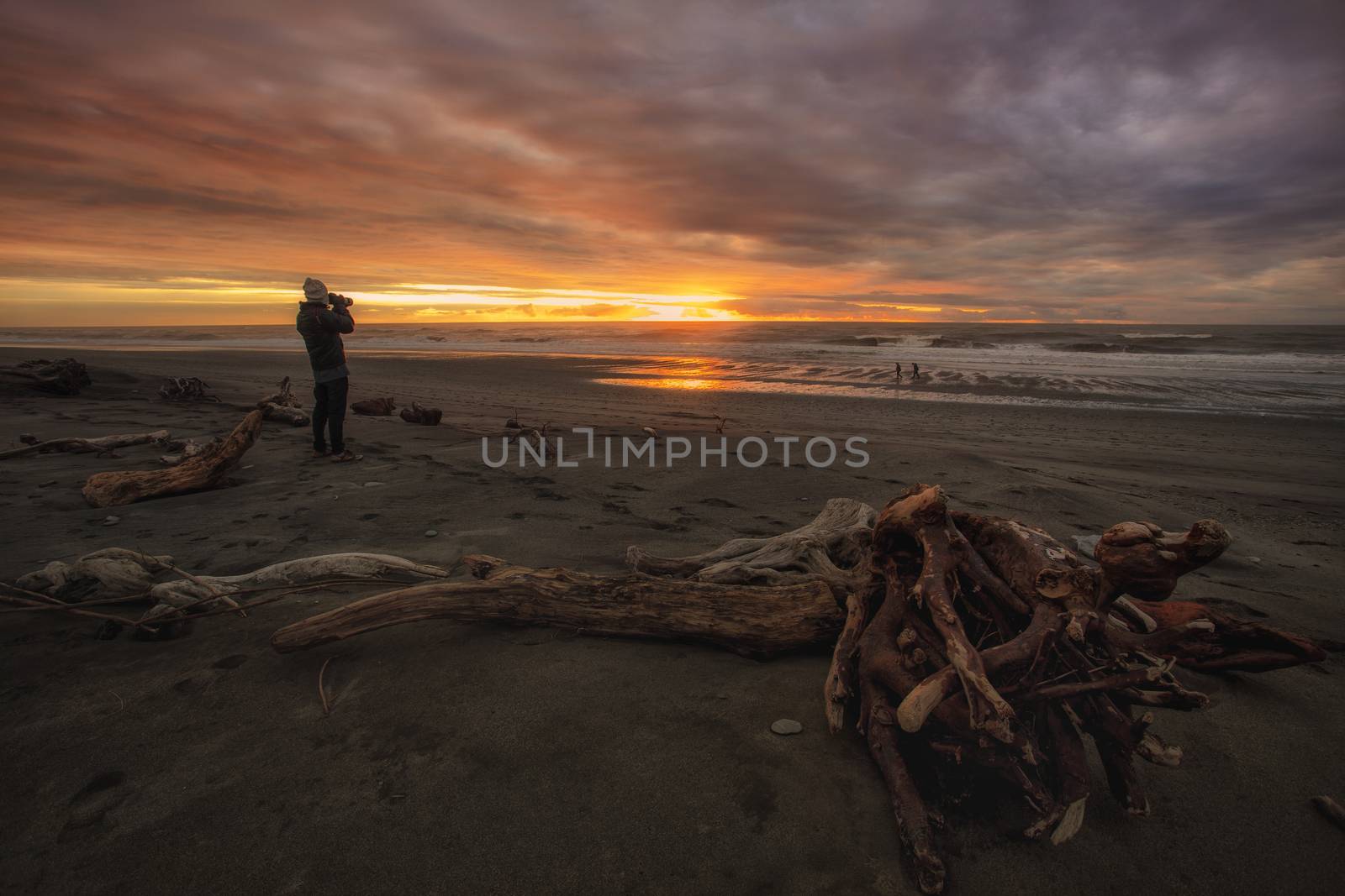photographer and hokitika beach sun set by khunaspix