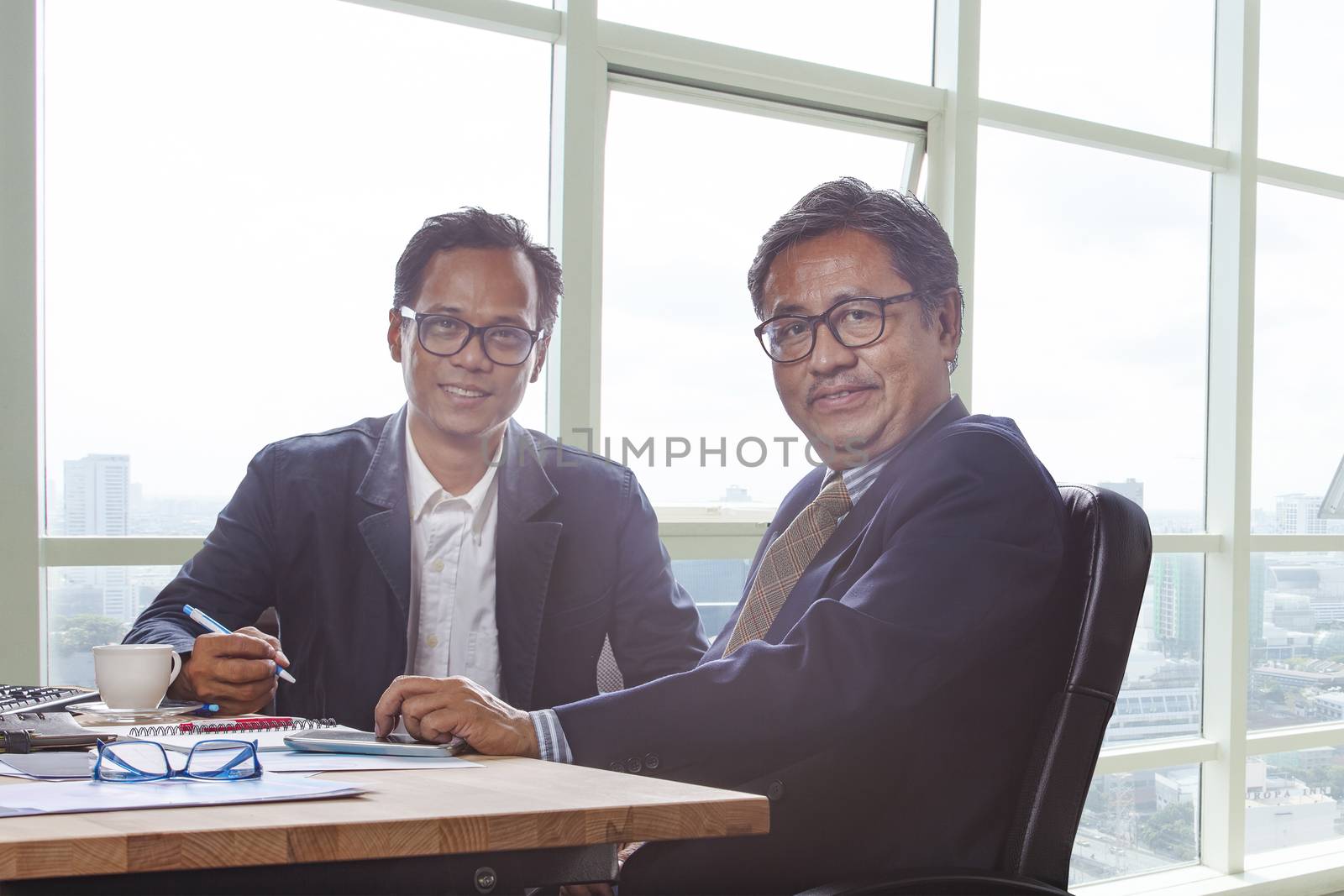 couples of business man working on office working table with smiling face looking to camera