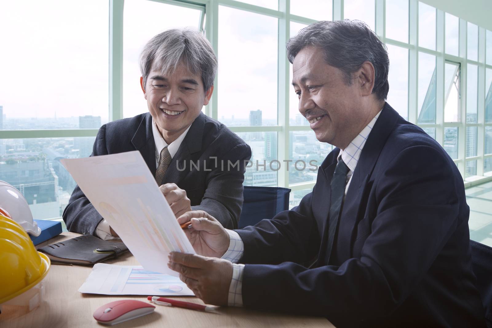 partner of senior engineering working man serious meeting about project discussing solution shot on table in office meeting room 