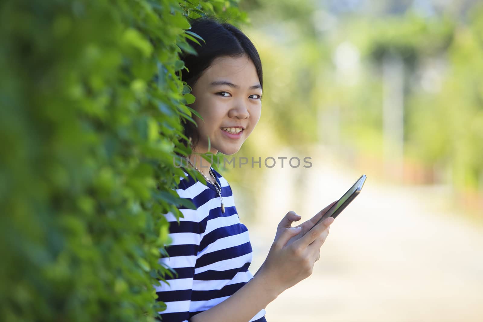 asian leaning green leaves with computer tablet in hand smiling face happiness emotion