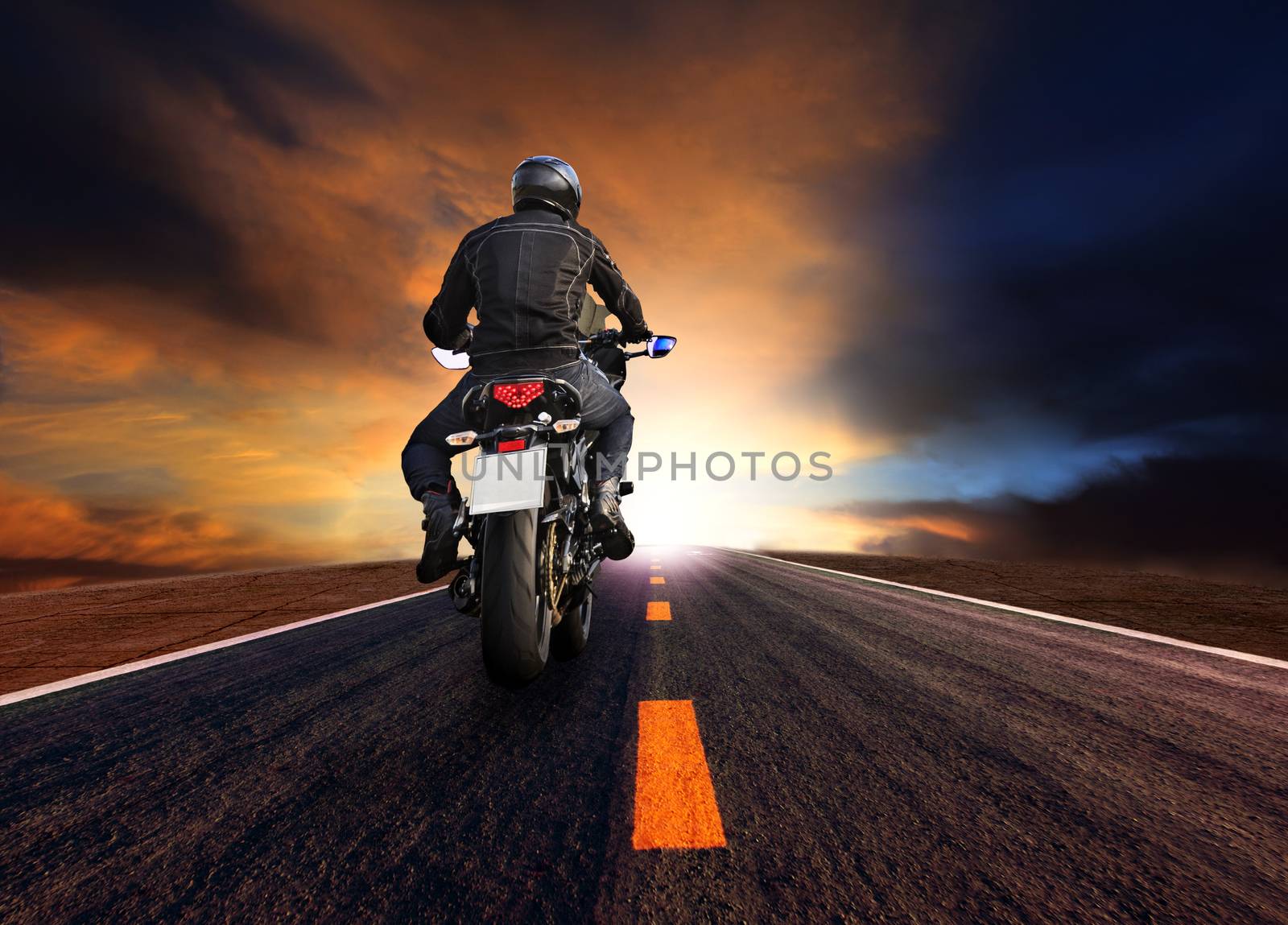man riding motorcycle on highway against beautiful  sun set sky 