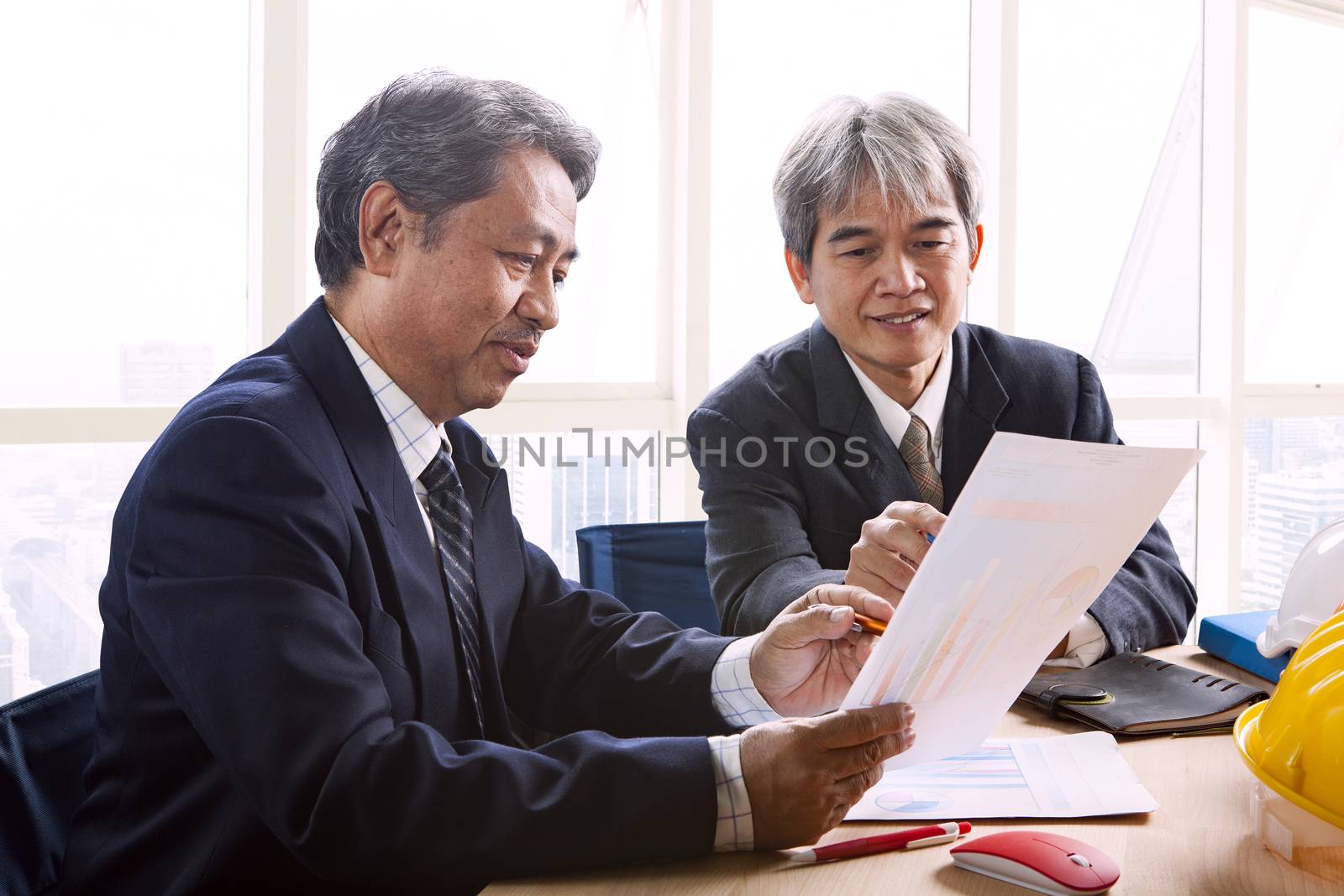 partner of senior engineering working man serious meeting about project discussing solution shot on table in office meeting room