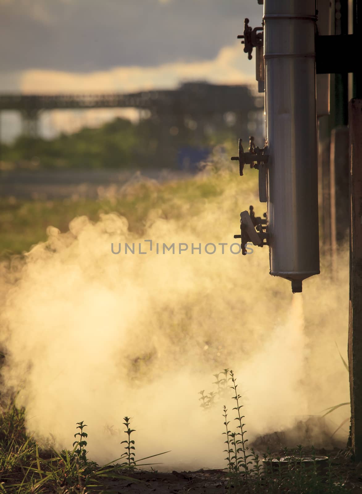 pressure pipe with smoke flowing from metal tube in oil refinery by khunaspix