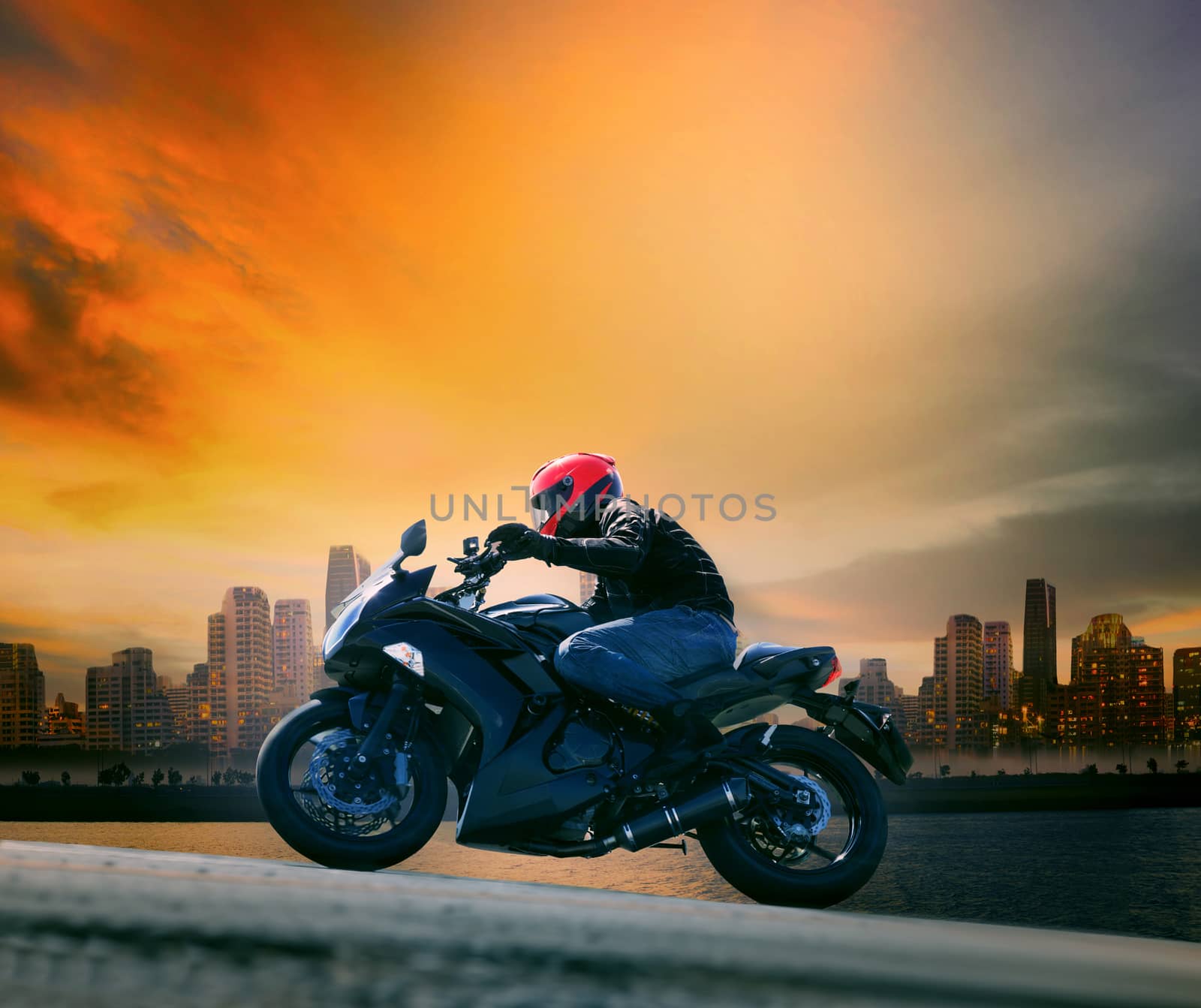 young man and safety suit riding big motorcycle against beautifu by khunaspix