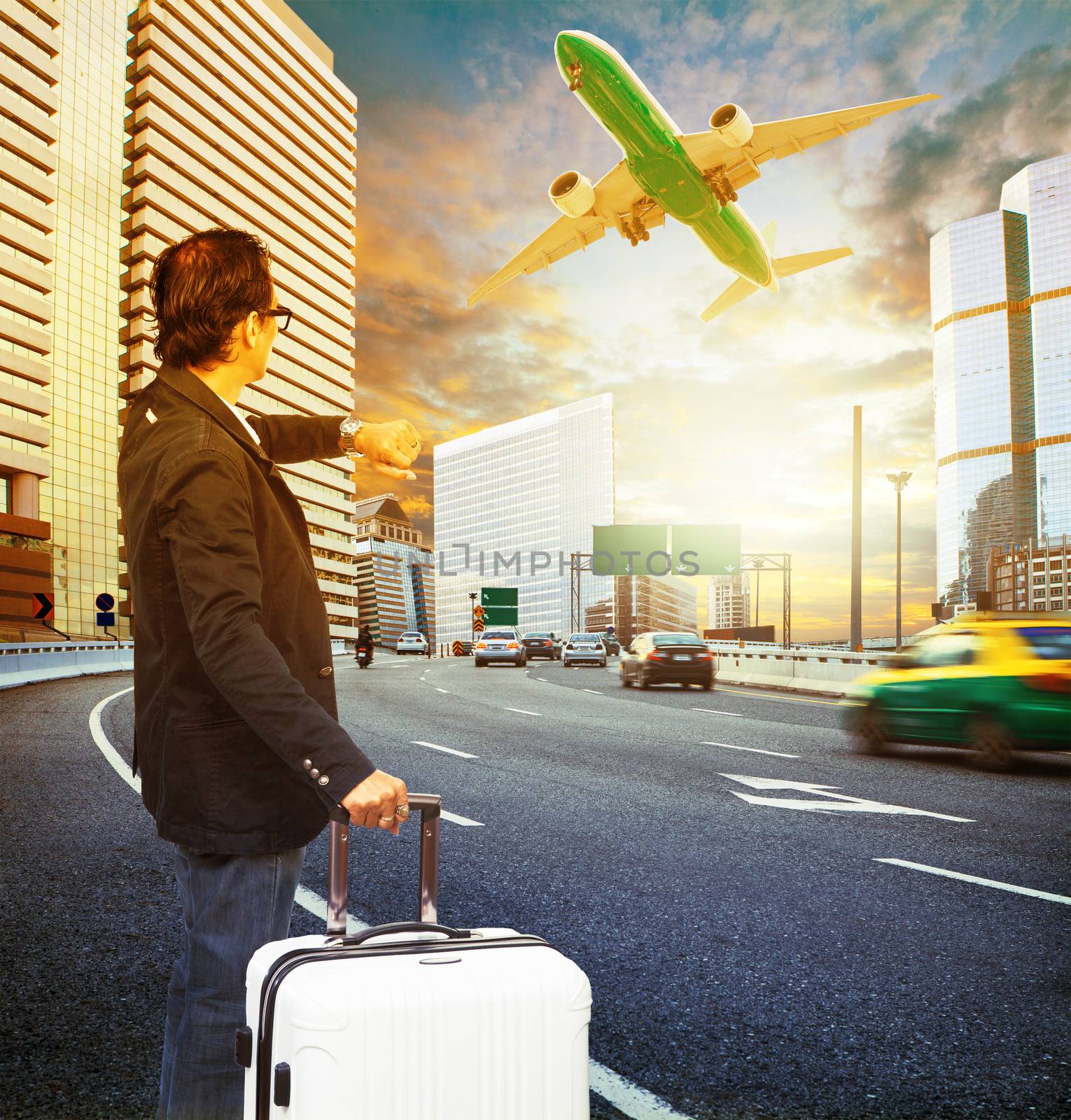 traveler man and luggage standing on traffic and looking to time watch against passenger car and airplane flying above