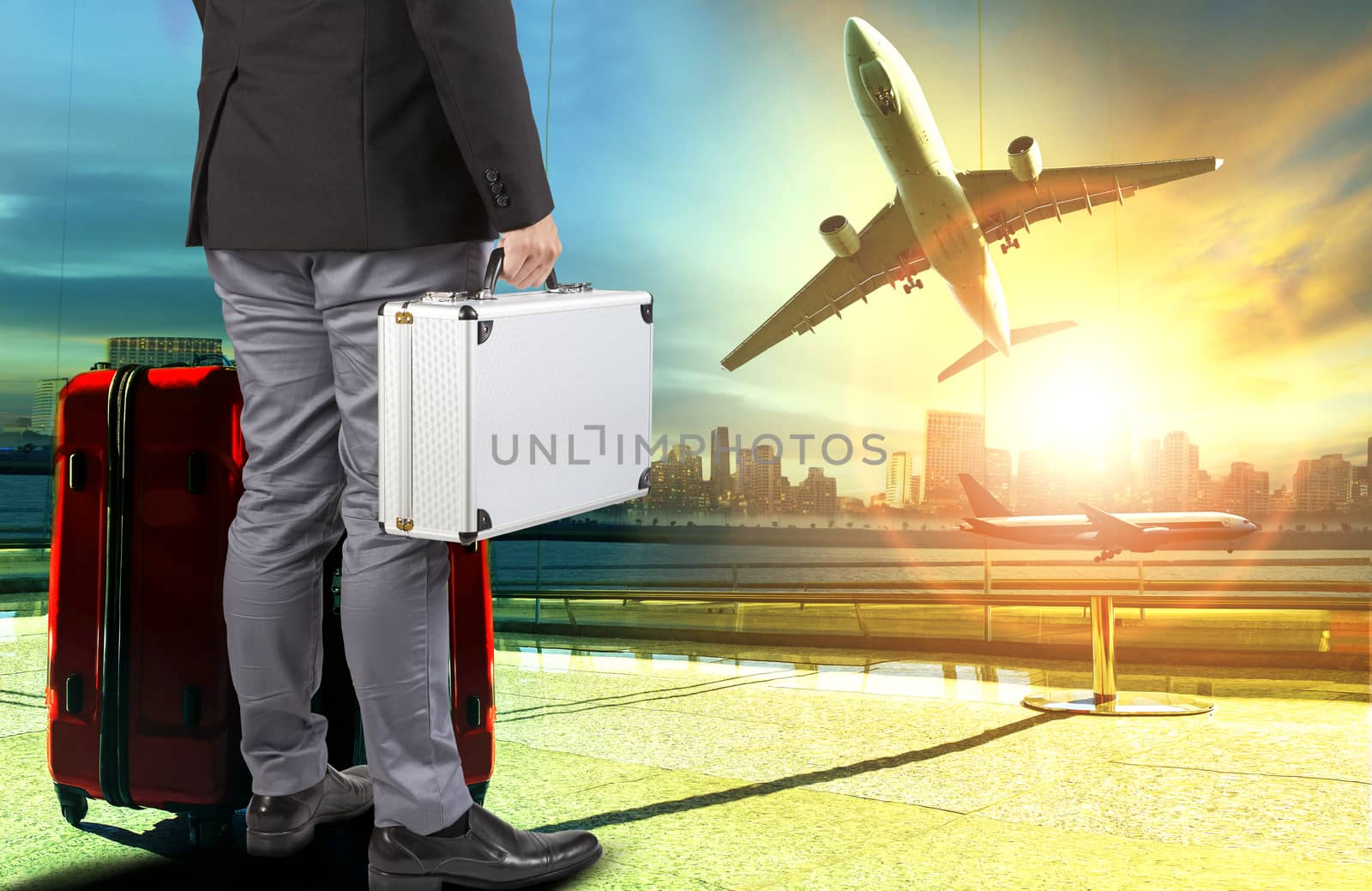 business man and breifcase ,traveling luggage standing in airport terminal building and passenger plane flying over sky