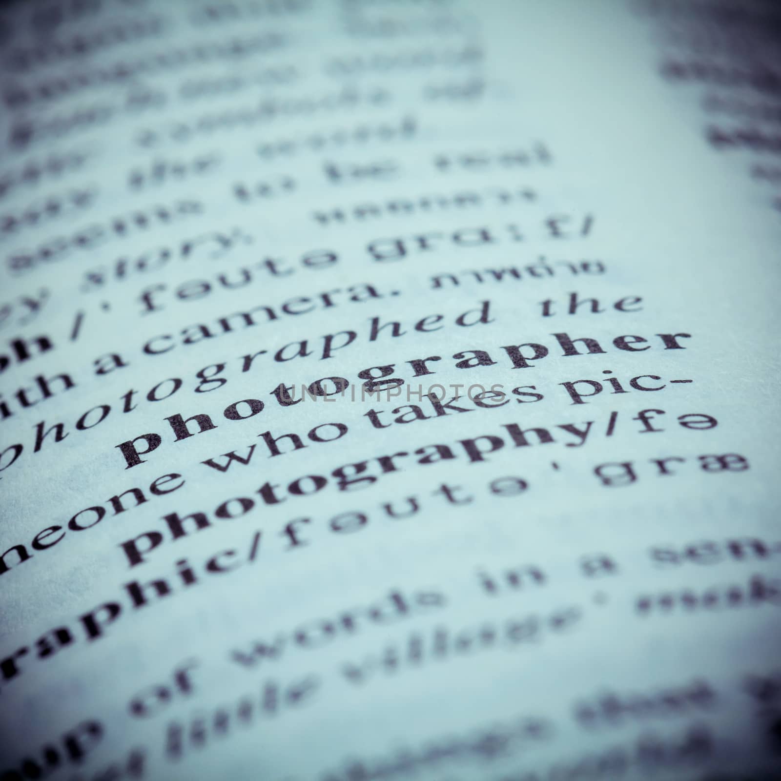 Close up of old English dictionary page with word Photographer. Shallow depth of field and toned page of word Photographer on English dictionary .
