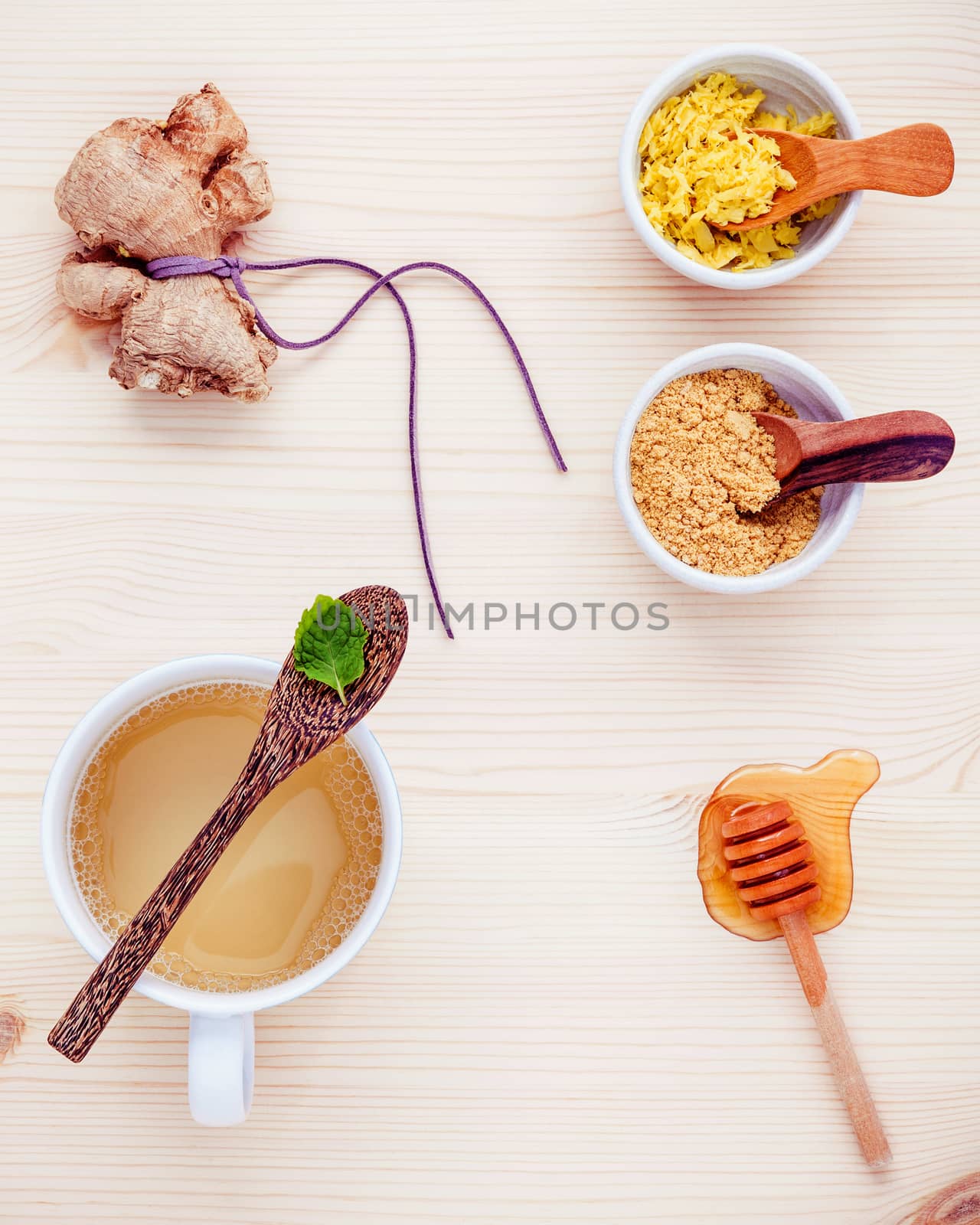 Herbal tea cup  with ginger tea , ginger roots ,peppermint and honey on  wooden background flat lay. Healthy beverage hot ginger tea and ingredients.