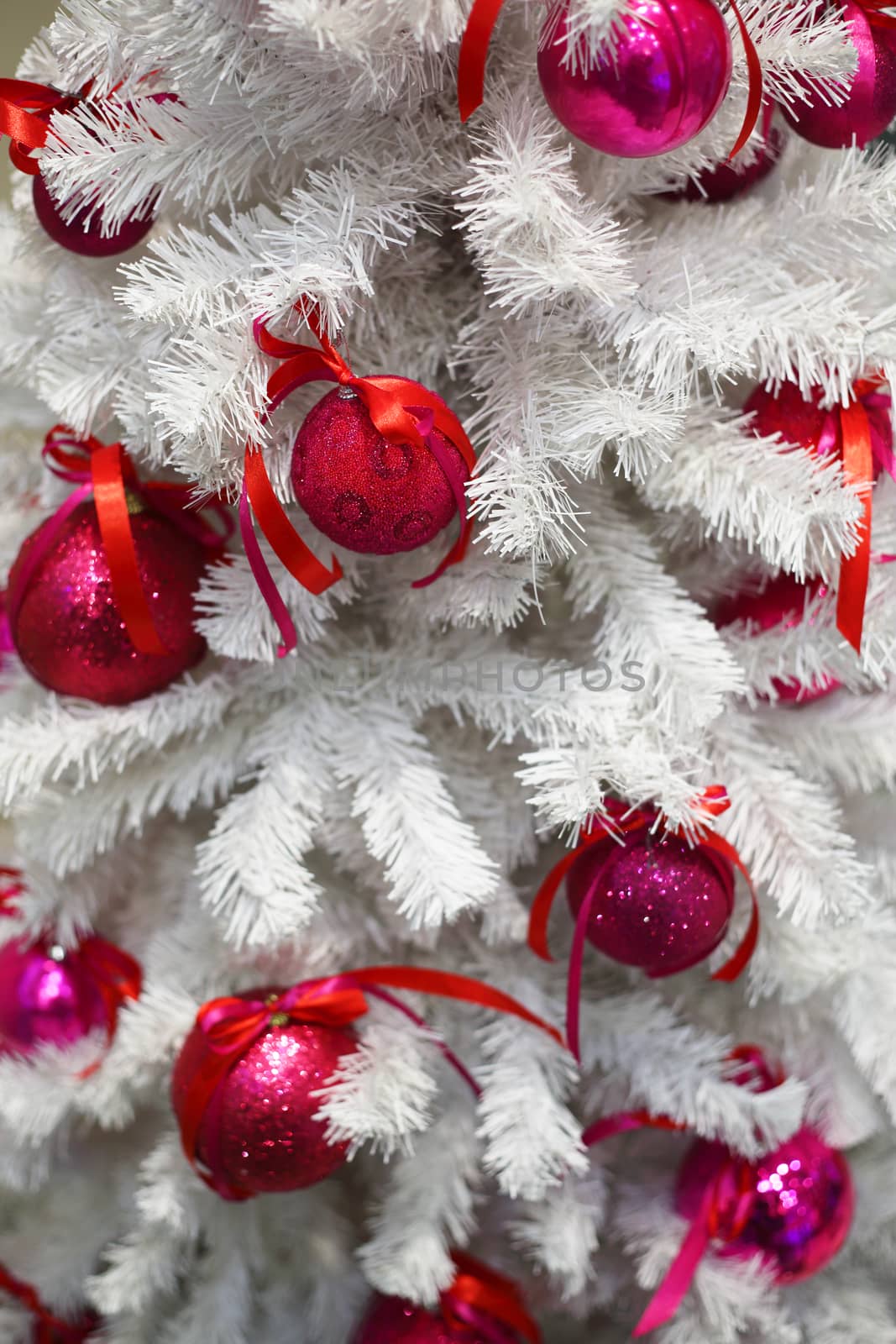 White Christmas tree with red decorative baubles close-up