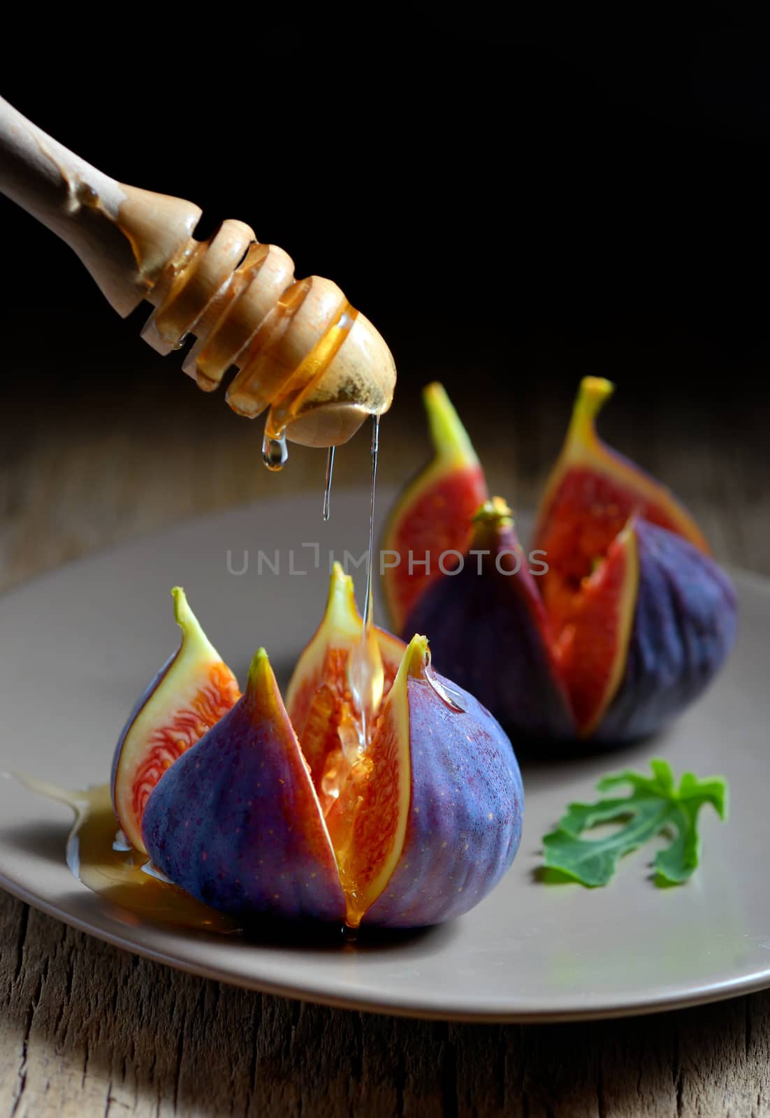 Honey dipper and figs on plate