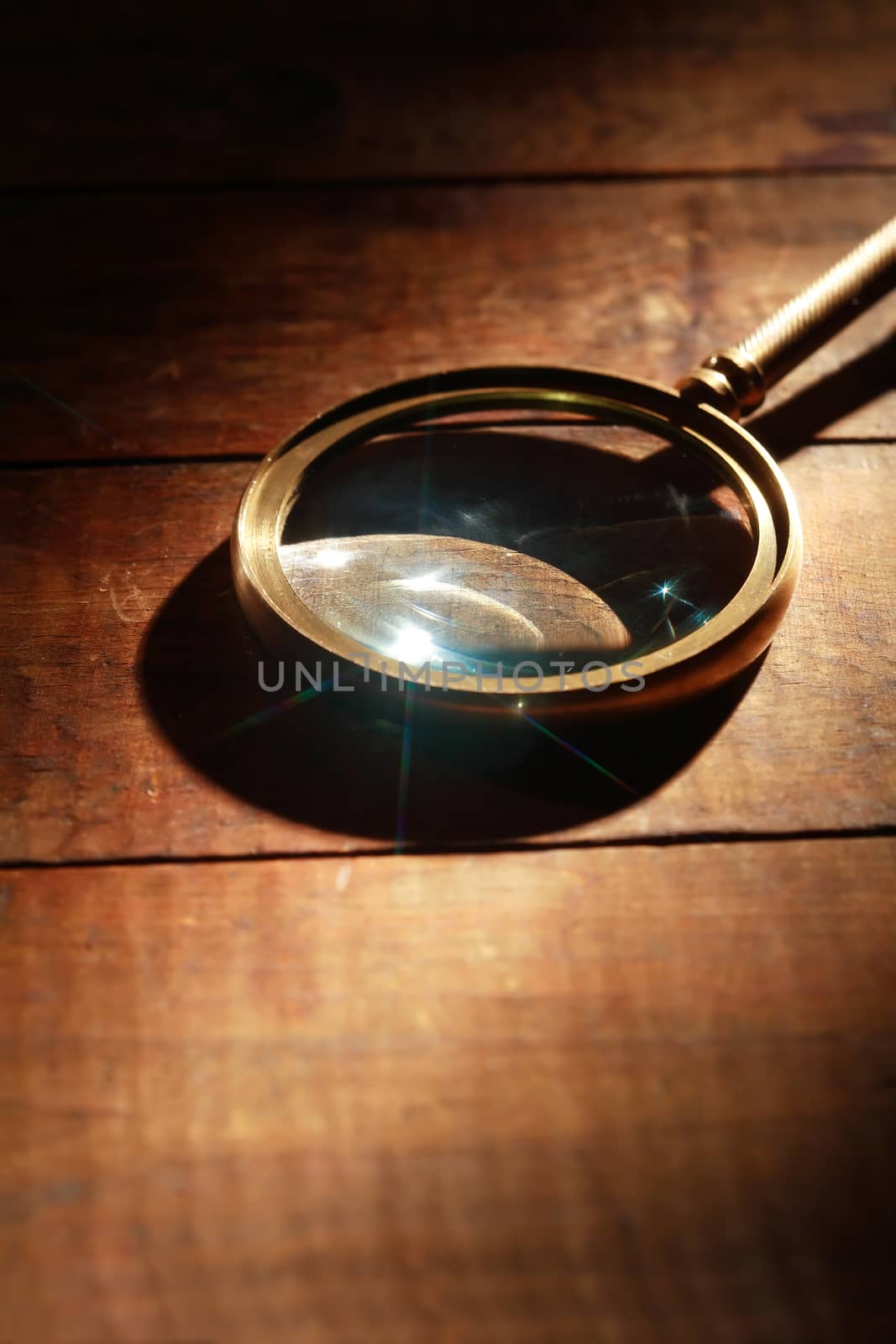 Magnifying glass with long shadow on wooden background