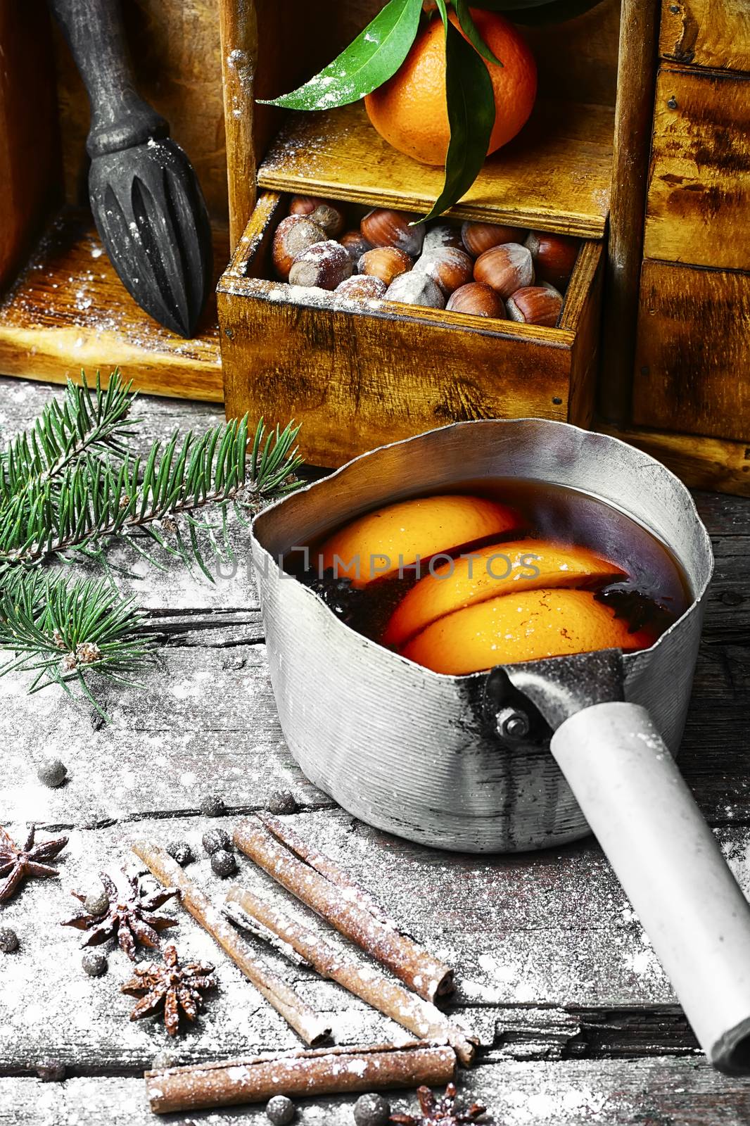 Hot red wine with oranges and cupboard with spices